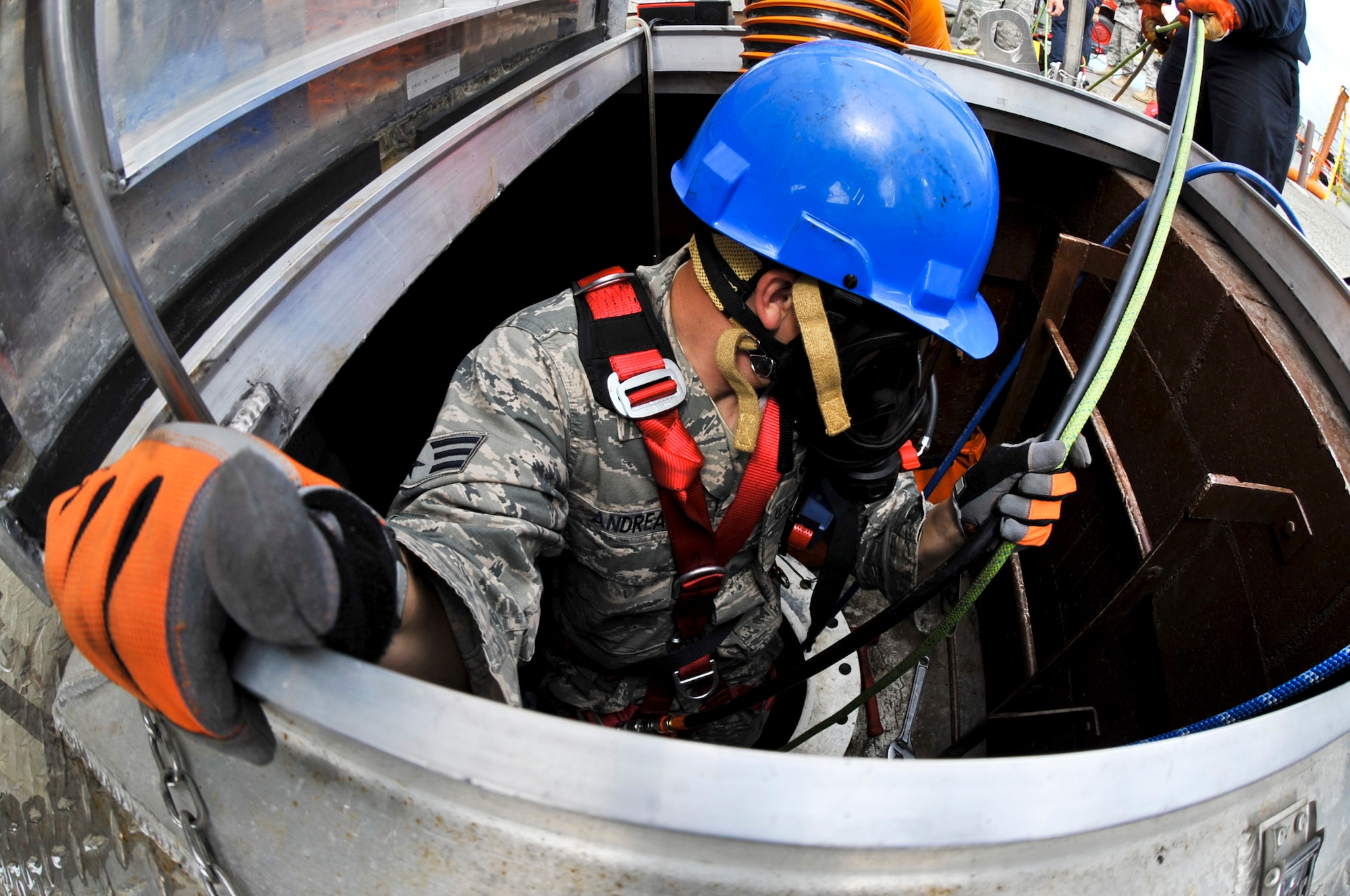 JOINT BASE ELMENDORF-RICHARDSON, Alaska – Senior Airman Justin Andreas, Joint Base Elmendorf-Richardson firefighter, makes his way down into an underground jet fuel tank to perform a confined space entry rescue drill June 30. JBER firefighters are required to be involved in this type of exercise annually. (Air Force photo by Airman 1st Class Christopher Gross)