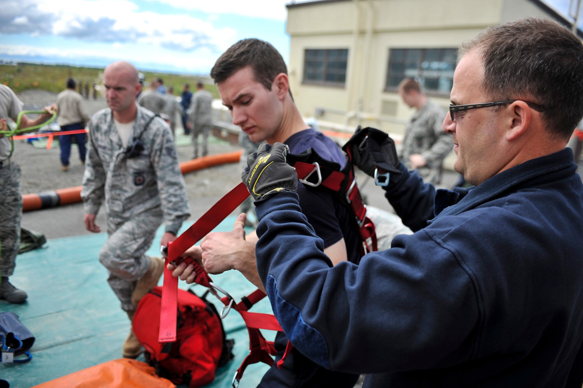 JOINT BASE ELMENDORF-RICHARDSON, Alaska -- Mr. Blayne Ross, Joint Base Elmendorf-Richardson firefighter, receives help from a fellow JBER Fire Department member while preparing for a confined space entry rescue drill June 30. JBER firefighters are required to be involved in this type of exercise annually. (Air Force photo by Airman 1st Class Christopher Gross)