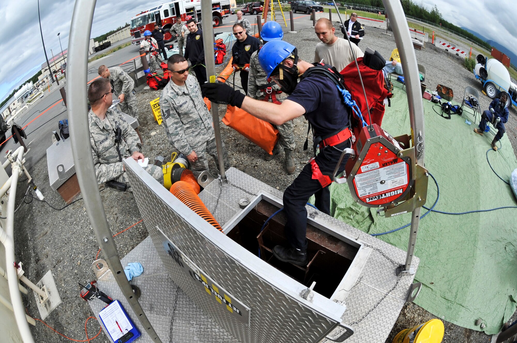 JOINT BASE ELMENDORF-RICHARDSON, Alaska – Mr. Blayne Ross, Joint Base Elmendorf-Richardson firefighter, readies himself to be lowered into an underground jet fuel tank June 30. For this scenario, members of the JBER Fire Department performed a confined space entry rescue drill where an Airman was trapped in the tank because of an injury. JBER firefighters are required to be involved in this type of exercise annually. (Air Force photo by Airman 1st Class Christopher Gross)