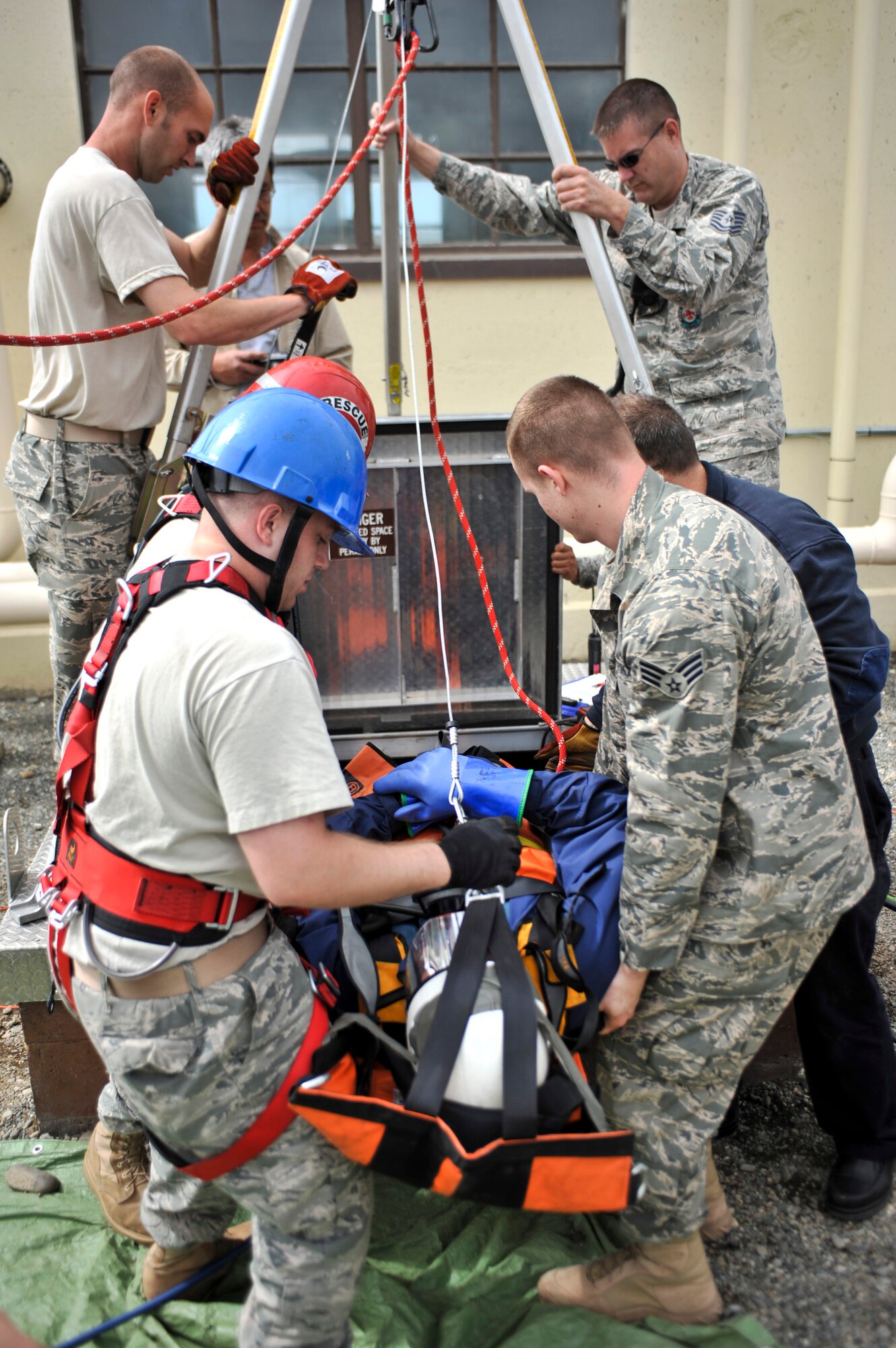 JOINT BASE ELMENDORF-RICHARDSON, Alaska – Members of the Joint Base Elmendorf-Richardson Fire Department help pull out a simulated injured Airman during a confined space entry rescue drill June 30. JBER firefighters are required to be involved in this type of exercise annually. (Air Force photo by Airman 1st Class Christopher Gross)