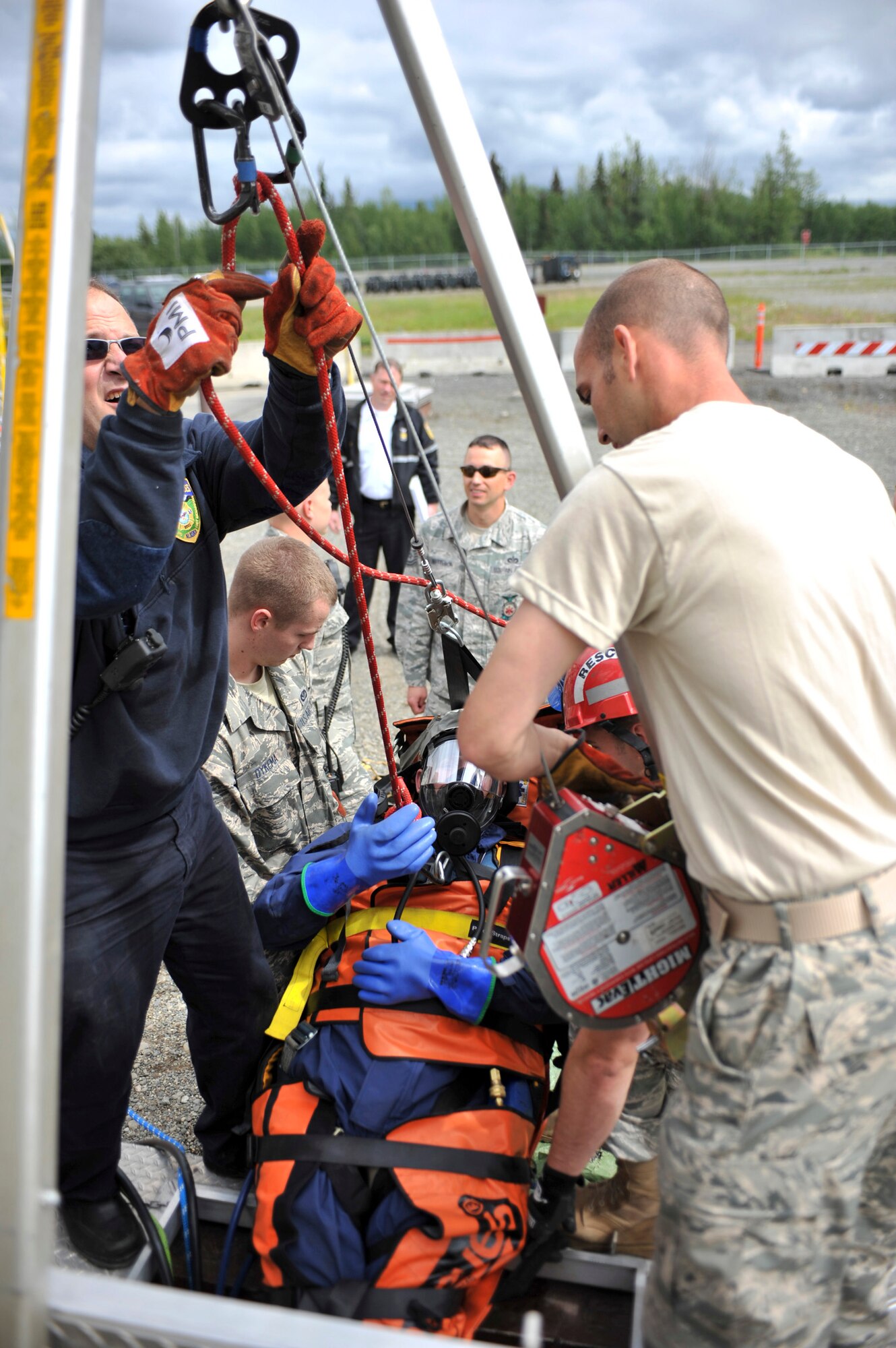 JOINT BASE ELMENDORF-RICHARDSON, Alaska – Members of the Joint Base Elmendorf-Richardson Fire Department help pull out a simulated injured Airman during a confined space entry rescue drill June 30. JBER firefighters are required to be involved in this type of exercise annually. (Air Force photo by Airman 1st Class Christopher Gross)