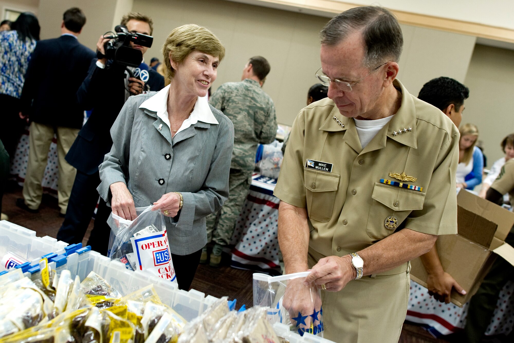 Adm. Mike Mullen, chairman of the Joint Chiefs of Staff, and his wife Deborah participate in the USO care package packing party at the Pentagon, July 2, 2010.  The packages contain items such as international calling cards, toiletries and entertainment items that provide a touch of home to servicemembers. In the most recent podcast to troops, Admiral and Mrs. Mullen discussed stresses on military families and efforts to alleviate them.  (Defense Department photo/Petty Officer 1st Class Chad J. McNeeley)