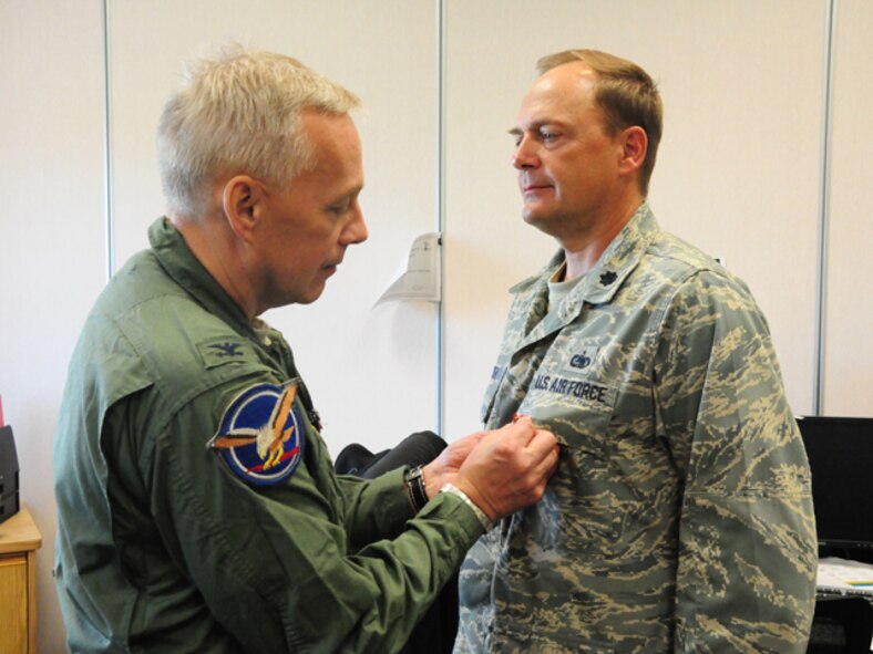 Lt. Col. Todd Branden, the 119th Wing deputy Mission Support Group commander, right, receives the U.S. Air Force Meritorious Service Medal for outstanding achievement from Col. Rick Gibney, the 119th Wing commander, July 2, at the North Dakota Air National Guard, Fargo, N.D. Branden received the award as a result of his outstanding leadership during the recent North Dakota Air National Guard mission transitions from the F-16 aircraft into the MQ-1 Predator and the C-21 aircraft during the time period of Oct 1, 2006 to Sep. 29, 2009.  The 119th Mission Support Group has been highly tasked during the transitions with planning, resourcing, training and restructuring base facilities, personnel, equipment, and security, and Lt. Col. Branden has been influential in those processes.