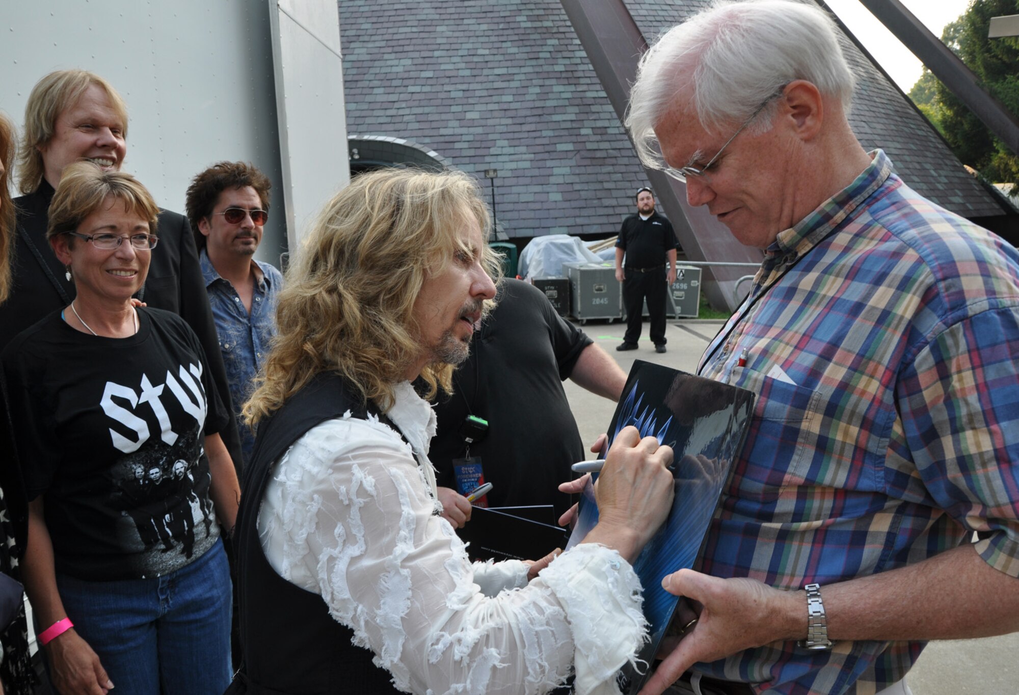 CUYAHOGA FALLS, Ohio— Air Force Reservist, Col. Teresa Hams, commander of the 910th Mission Support Group, watches Tommy Shaw, lead singer for the rock group Styx, as he autographs a band lithograph to be displayed at Youngstown Air Reserve Station's Eagle's Nest Club.  Col. Hams along with approximately 20 other Citizen Airmen from the 910th Airlift Wing enjoyed a night out at Blossom Music Center here June 26.  The Airmen enjoyed performances by Kansas, Foreigner and Styx.  This was all made possible through the Air Force Reserve's Get One Now recruiting outreach program.  For more information about the Get One Now program as well as a career in the Air Force Reserve, call 1-800-257-1212. U.S. Air Force Photo by Maj. Brent J. Davis  