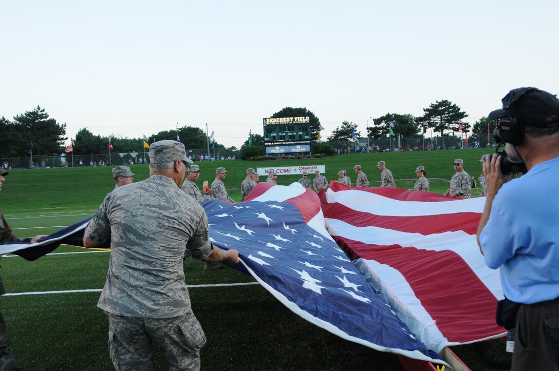 Members of the 155th Air Refueling Wing Nebraska Air National Guard unfurl a large American flag during the annual opening ceremonies of the Cornhusker State Games held at Seacrest field in Lincoln, Neb. on June 25, 2010. The Cornhusker State Games are olympic style sporting events held annually in Lincoln, Neb. for all citizens in the state of Nebraska. (Nebraska Air National Guard photo by Senior Master Sgt. Lee Straube)