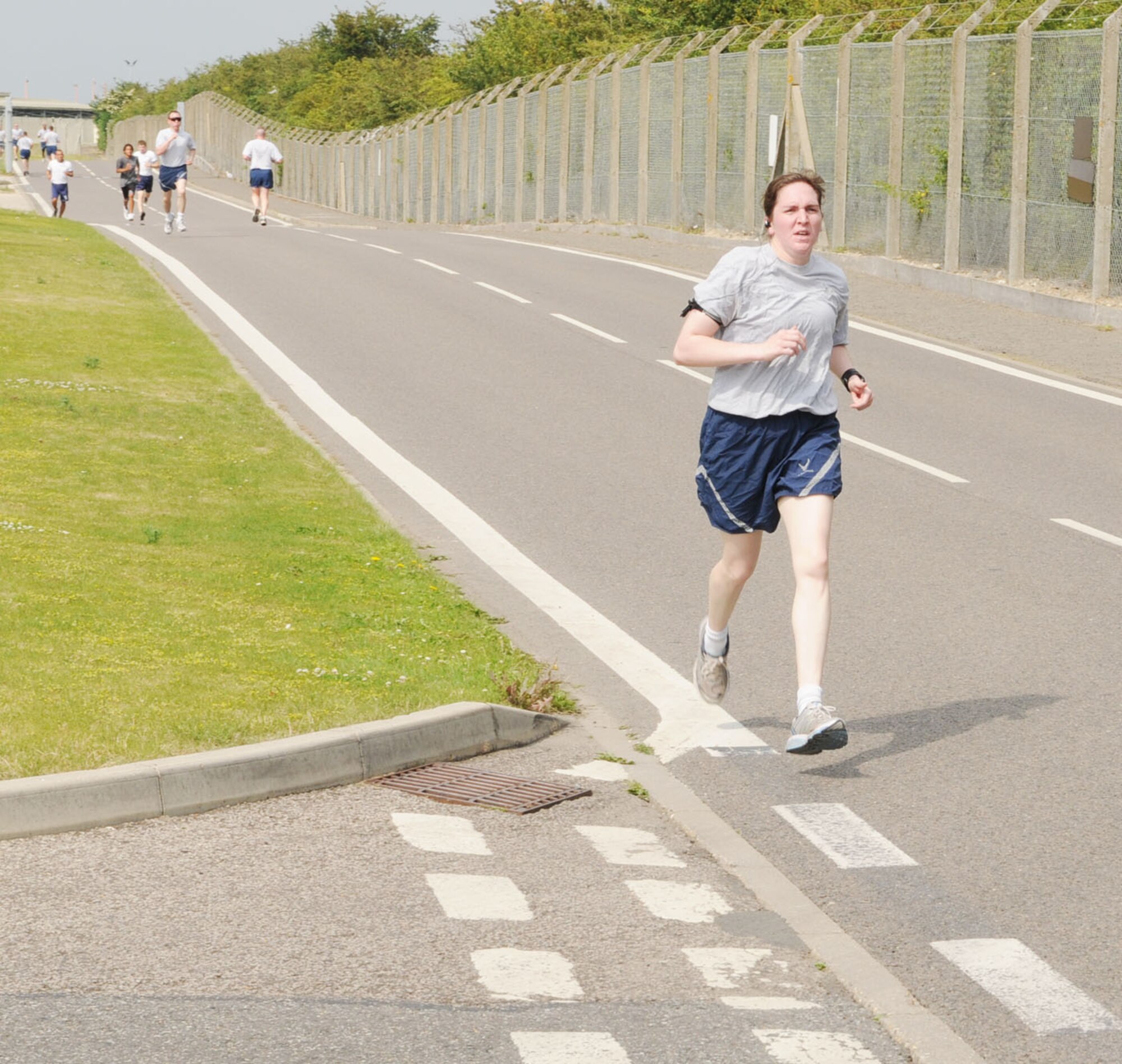 RAF MILDENHALL, England -- Capt. Michelle Baxter, 100th Logistics Readiness Squadron, prepares to cross the finish line, earning her position of the first woman to finish June 25 at a 100th Air Refueling Wing 5K fun run. The monthly event is held to promote health and fitness amongst 100th ARW members. (U.S. Air Force photo/Karen Abeyasekere)