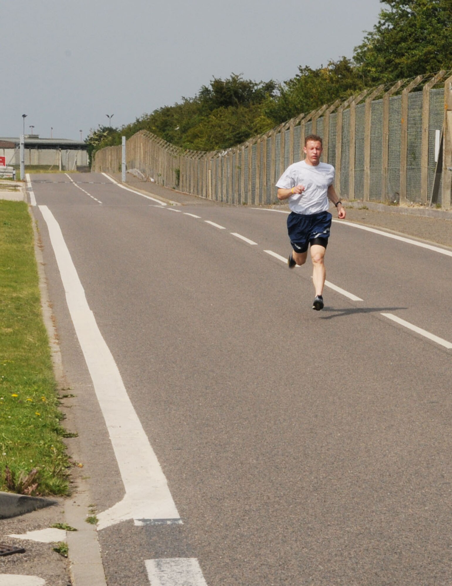 RAF MILDENHALL, England -- Airman 1st Class Jon Porubsky, 100th Security Forces Squadron, races home into first place at a 100th Air Refueling Wing 5K fun run June 25. This is the second consecutive month Airman Porubsky has taken first place in the wing run, with a time for this month's event of 17:39 minutes. (U.S. Air Force photo/Karen Abeyasekere)