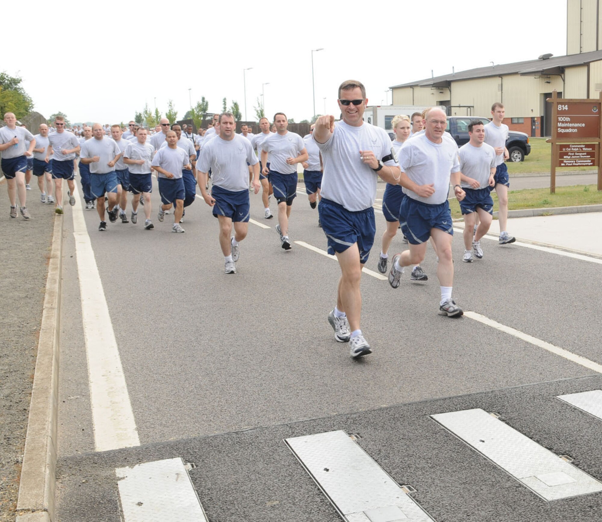 RAF MILDENHALL, England -- Lt. Col. Bruce McNaughton, front with sunglasses, 100th Air Refueling Wing director of staff, and other members of the 100th ARW run a 5K wing fun run June 25 at the running area near the Hardstand Fitness Center. The wing fun run is a monthly event to promote health, fitness and camaraderie amongst base members. (U.S. Air Force photo/Karen Abeyasekere)