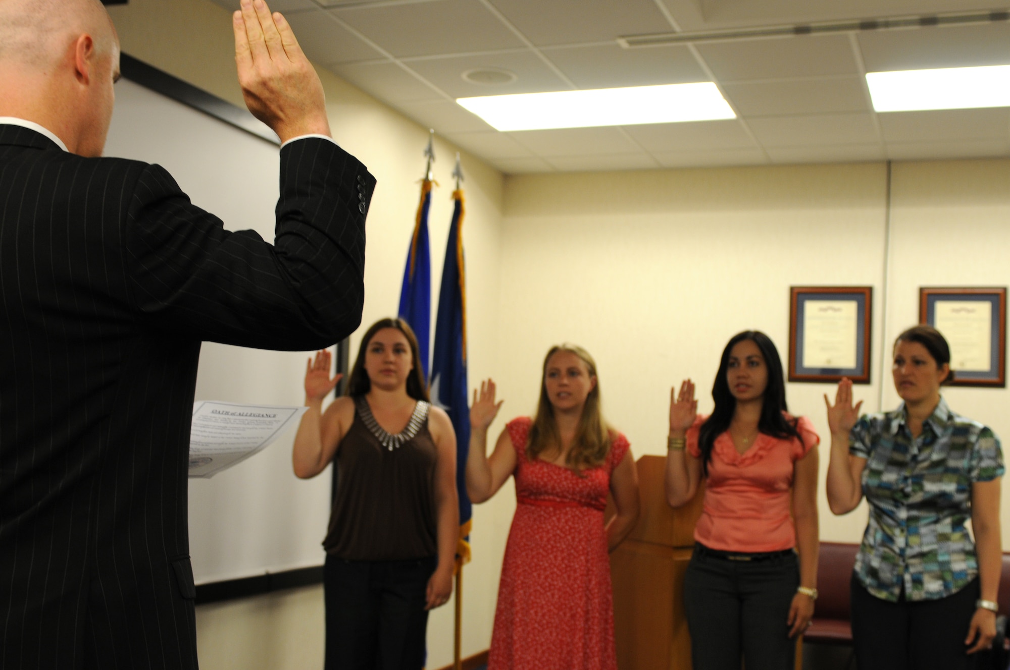 John Lafferty, District Director, U.S. Citizenship and Immigration Services, administers the Oath of Allegiance during a military naturalization ceremony June 30. The four candidates are spouses to Air Force members stationed throughout Italy. (U.S. Air Force photo/ Staff Sgt. Nadine Y. Barclay)