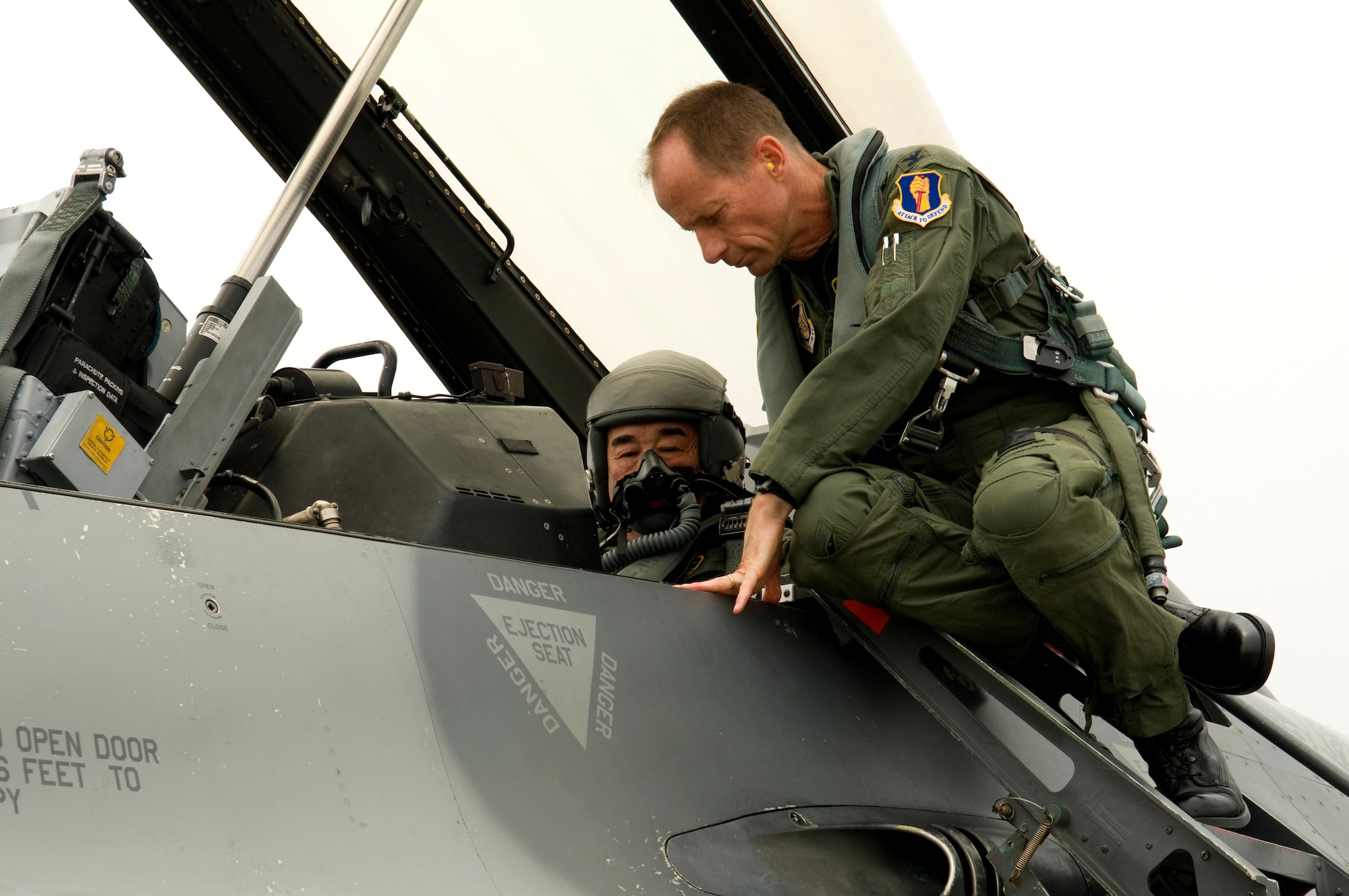MISAWA AIR BASE, Japan -- Col. David Stilwell, 35th Fighter Wing commander, explains to Kazumasa Taneichi, Misawa City mayor and honorary commander for the day, how to communicate in the cockpit, July 2. Once ready, the two taxied down the flightline giving the mayor a snapshot of the 35th Fighter Wing mission. (U.S. Air Force photo/1st Lt. Jeff M. Nagan)