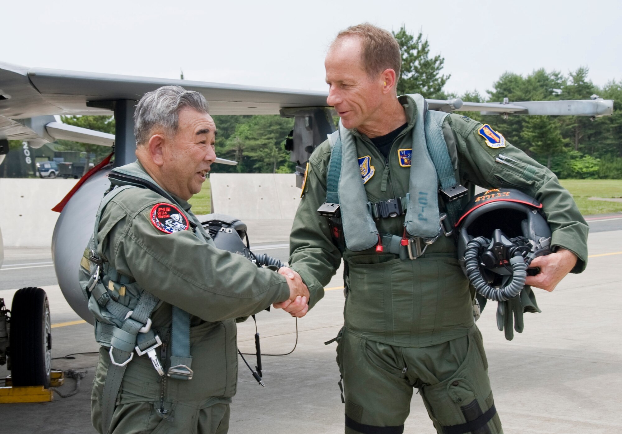 MISAWA AIR BASE, Japan -- Col. David Stilwell, 35th Fighter Wing commander, shakes hands Misawa City Mayor and honorary commander Kazumasa Taneichi after they taxied the flightline, July 2. The honorary wing commander program is part of a community relation project that began with Col. Stillwell being ?Mayor for the day? May 23. (U.S. Air Force photo/ Staff Sgt Araceli Alarcon)