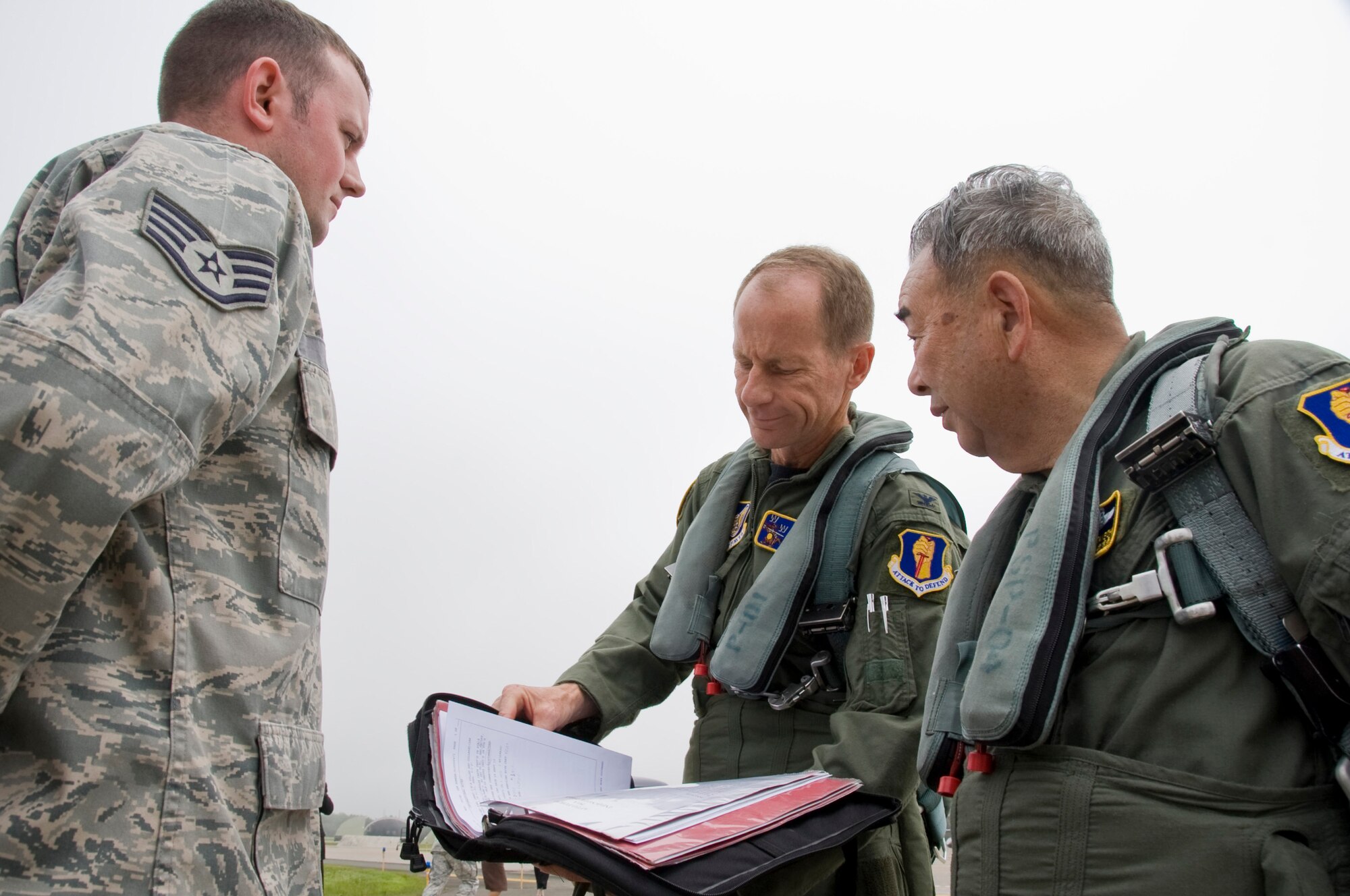 MISAWA AIR BASE, Japan -- Col. David Stilwell, 35th Fighter Wing commander, Misawa City Mayor Kazumasa Taneichi and Staff Sgt. Sean Moore, 35th Aircraft Maintenance Squadron, crew chief, reviews the jet log prior to taxiing the F-16 Fighting Falcon, July 2. Mayor Kazumasa Taneichi was given the opportunity to become familiar with one of Misawa AB?s F-16 Fighting Falcon. (U.S. Air Force photo/ Staff Sgt. Araceli Alarcon)