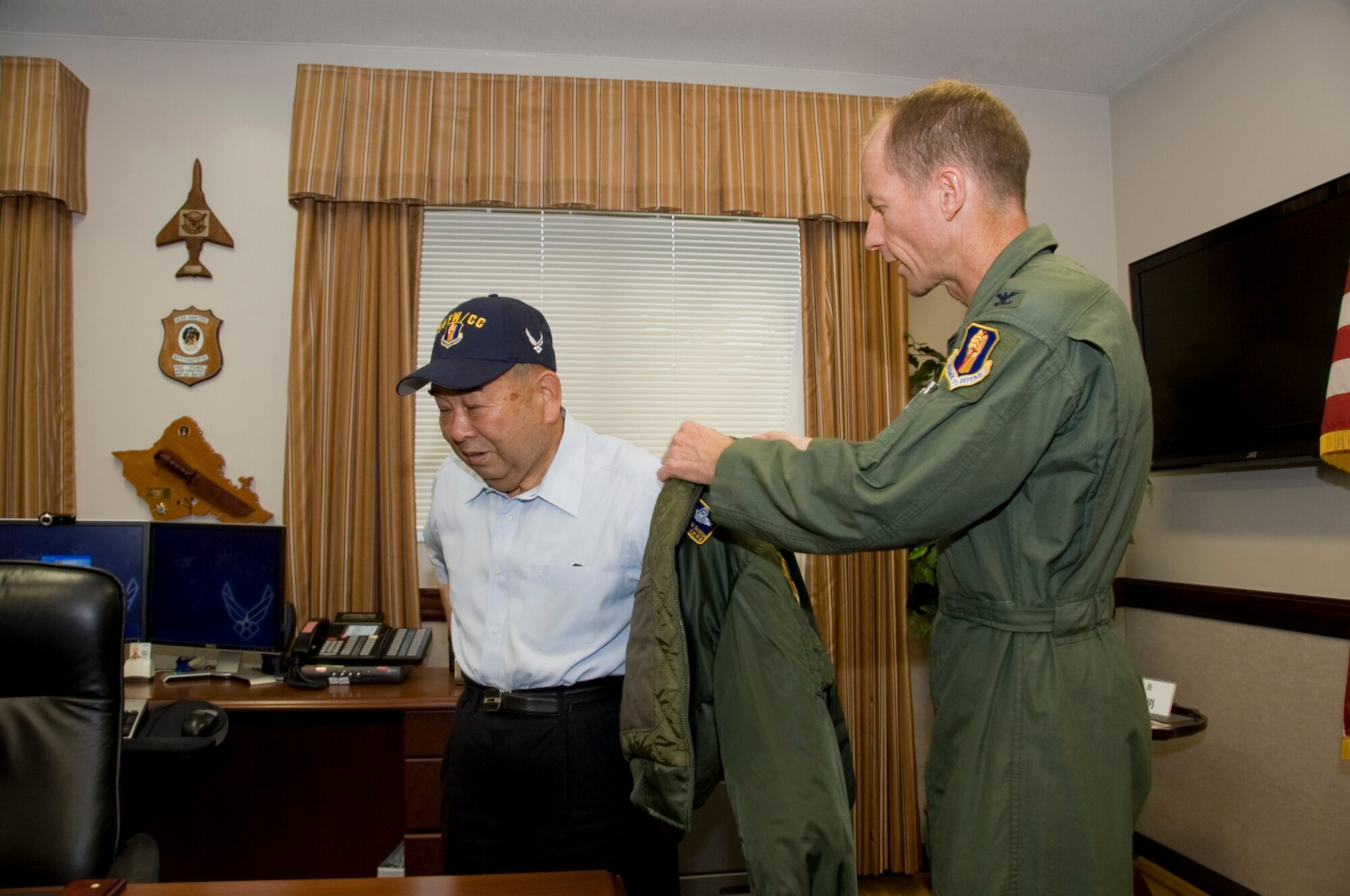 MISAWA AIR BASE, Japan -- Col. David Stilwell, 35th Fighter Wing commander presents Misawa City Mayor Kazumasa Taneichi with a flight jacket and a commander?s hat, July 2. Mayor Taneichi was given the chance to experience some of the duties as wing commander for the day.   (U.S. Air Force photo/ Staff Sgt. Araceli Alarcon) 