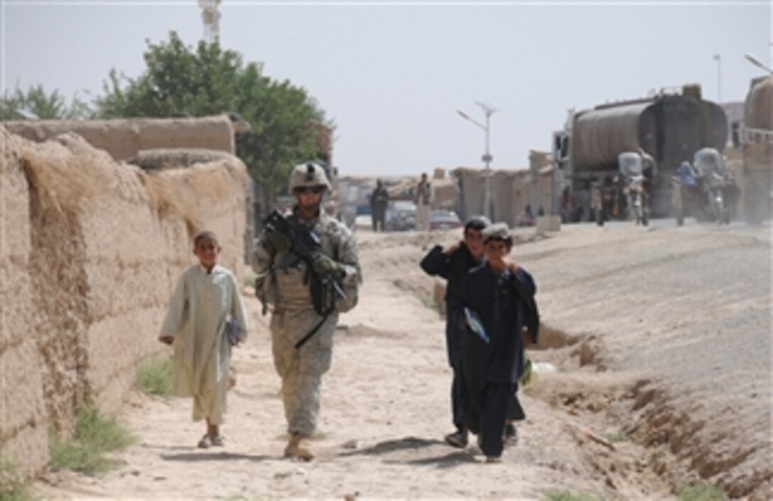Afghan children walk alongside U.S. Army Spc. Steven London, from 2nd Platoon, Delta Company, 1st Battalion, 4th Infantry Regiment, U.S. Army Europe, during a patrol outside Combat Outpost Sangar in Zabul province, Afghanistan, on June 27, 2010.  
