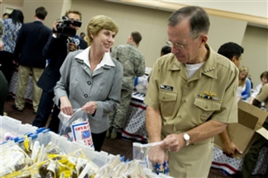 Chairman of the Joint Chiefs of Staff Adm. Mike Mullen and his wife Deborah participate in a USO care package packing party in the Pentagon on July 2, 2010.  The USO has delivered more than 1.3 million care packages to service members stationed overseas.  The packages contain items such as international calling cards, toiletries and entertainment items that provide a touch of home to service members.  