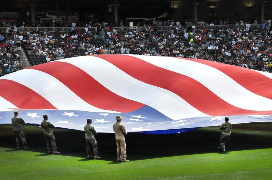 Members of the United States Armed Services unravel the U.S. flag during the Armed Services Appreciation Day at Target Field during the Minnesota Twins vs. Tampa Bay Rays baseball game, July 3. (U.S. Air Force photo/SrA Noah R. Johnson)