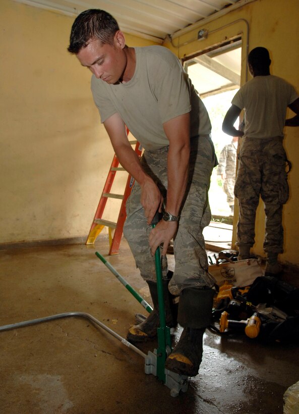Staff Sgt. Jed Waters, 820th Expeditionary RED HORSE Squadron, cuts electrical conduit at Sanson Elementary School July 2. (U.S. Air Force photo/Tech. Sgt. Eric Petosky)