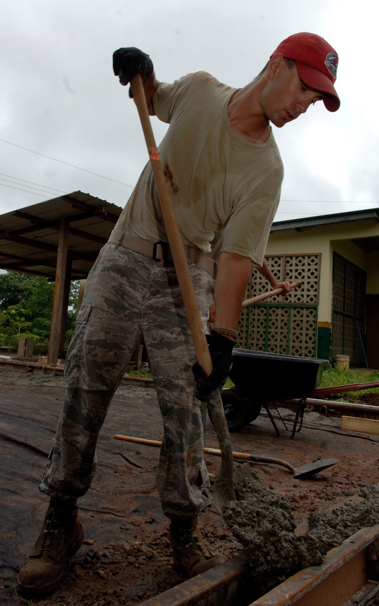 Senior Airman Randall Minor, 820th Expeditionary RED HORSE Squadron, shovels concrete into a form at Rio Iglesia Medical Clinic July 2. (U.S. Air Force photo/Tech. Sgt. Eric Petosky)