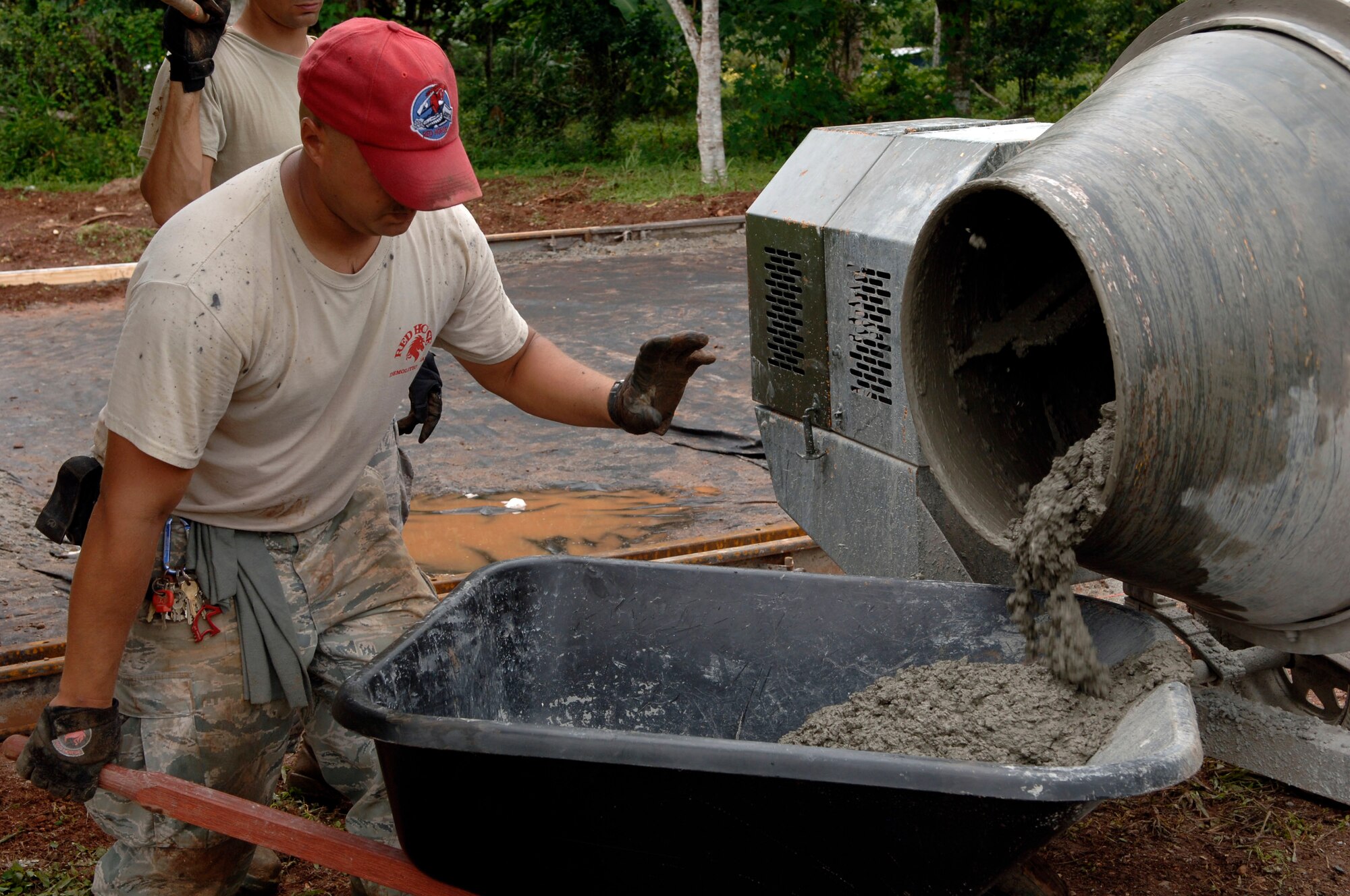 Staff Sgt. Jason Caceres, 820th Expeditionary RED HORSE Squadron, pours concrete into a wheelbarrow at Rio Iglesia Medical Clinic July 2. (U.S. Air Force photo/Tech. Sgt. Eric Petosky)
