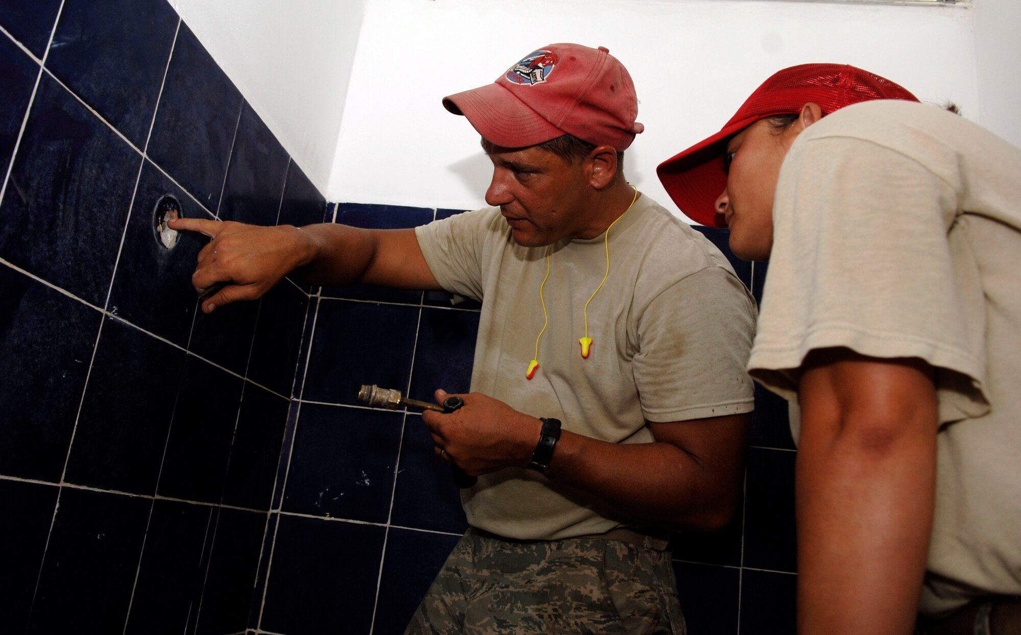 Staff Sgt. Matt Taubman (left) and Staff Sgt. Kristine Moss, 820th Expeditionary RED HORSE Squadron, works on the plumbing at Rio Iglesia Elementary School July 2. (U.S. Air Force photo/Tech. Sgt. Eric Petosky)