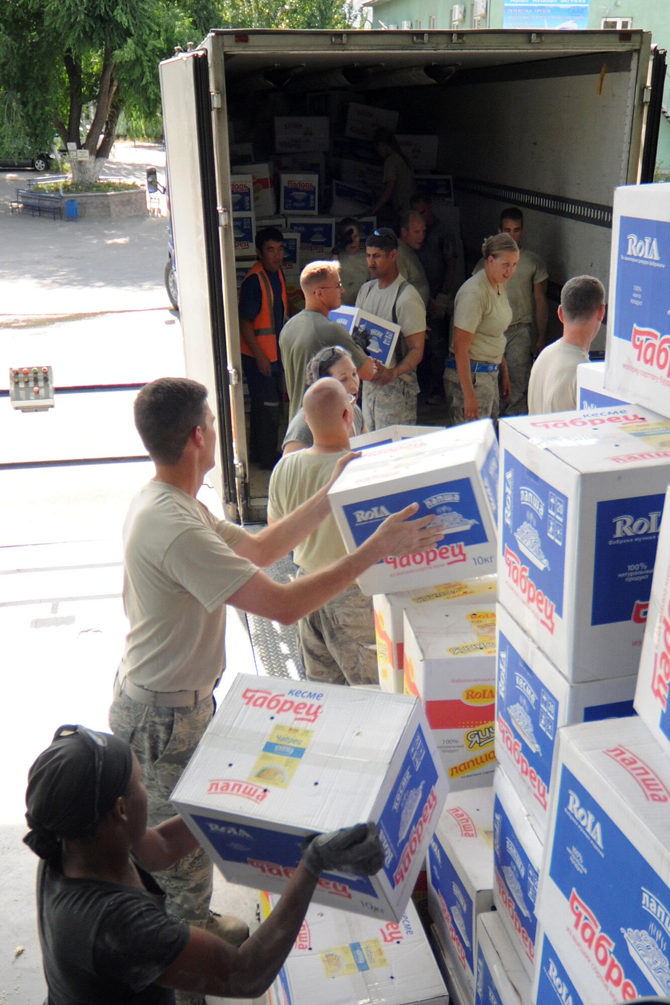 MANAS INTERNATIONAL AIRPORT, Kygryzstan - With just one hour?s notice, Command Chief Master Sgt. Chief Master Sergeant James Dowell asked for 10 volunteers and received 20 Airmen to help Kyrgyz relief workers load supplies headed for Osh July 3. (U.S. Air Force photo/Staff Sgt. Michael Schocker)