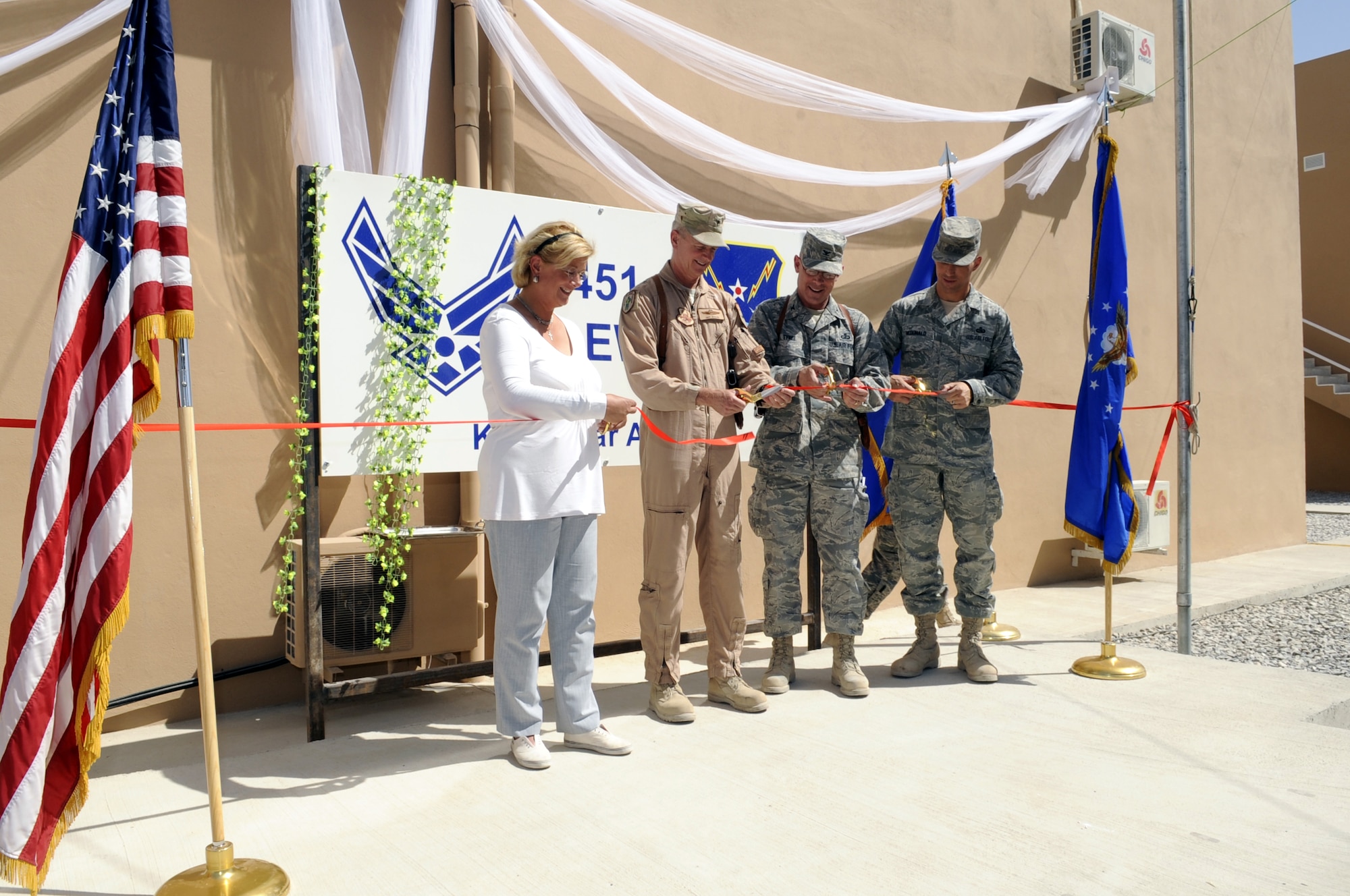 Ms. Zeynep Betty Tali, deputy general manager, KBY International Construction Co., Brig. Gen. Guy Walsh, 451st Air Expeditionary Wing commander, Col. Todd Tyree, 451st Expeditionary Mission Support Group commander, and 451st AEW Command Chief Master Sgt. Steve McDonald, participate in a ribbon-cutting ceremony July 2 to open brand-new work and living facilities, marking the one-year anniversary of the wing’s activation at Kandahar Airfield, Afghanistan.  (U.S. Air Force photo by Senior Airman Nancy Hooks/Released)
