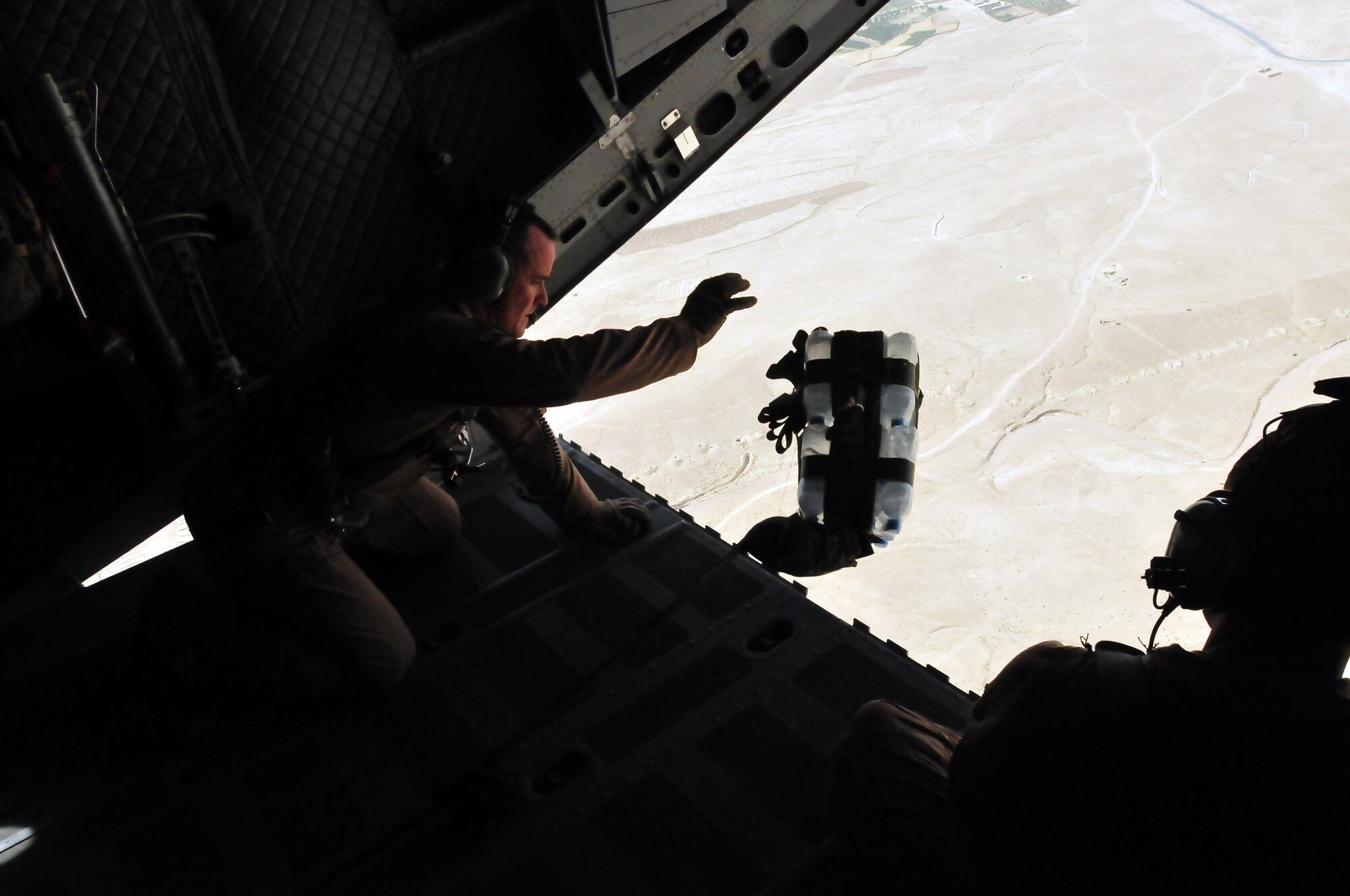 100701-N-6031Q-023 KABUL, Afghanistan -- Load Master, Master Sergeant Chris Ringland, 438th Air Expeditionary Advisory Group throws the cargo from the plane as Staff Sergeant Talon Martin, 538th Air Expeditionary Advisory Squadron, watches during an air drop on July 1, 2010. This is the first air drop conducted by any crew of the C-27 Spartan transport plane in Afghanistan. (US Navy photo by Mass Communication Specialist 2nd Class David Quillen/ RELEASED).