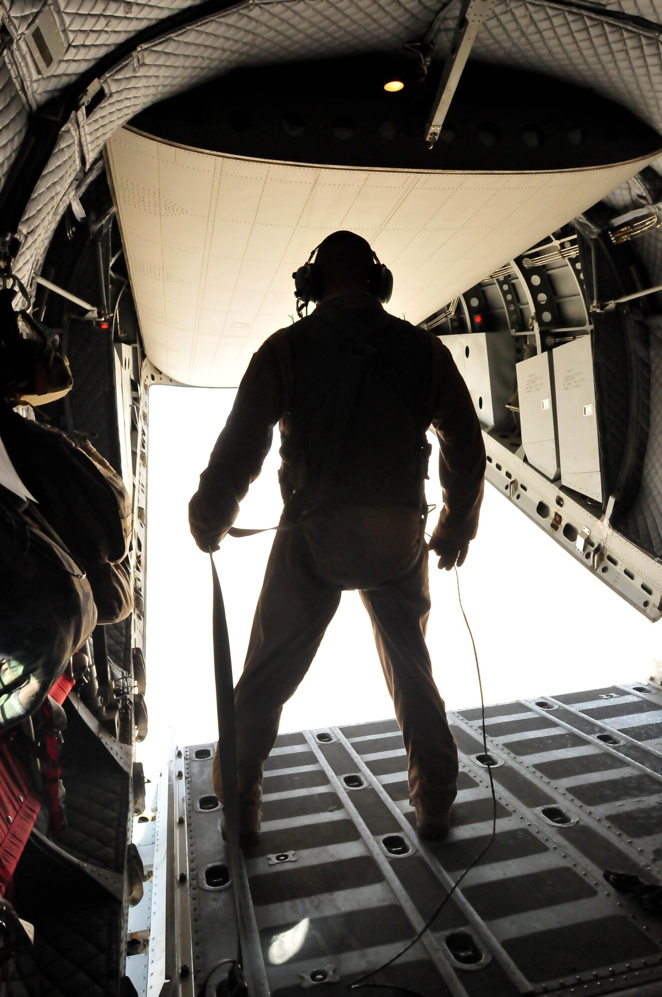 100701-N-6031Q-012 KABUL, Afghanistan -- Load Master, Master Sergeant Chris Ringland, 438th Air Expeditionary Advisory Group, prepares to launch the cargo from the back of a C-27 transport plane during an air drop on July 1, 2010. This is the first air drop conducted by any crew of the C-27 Spartan transport plane in Afghanistan. (US Navy photo by Mass Communication Specialist 2nd Class David Quillen/ RELEASED).
