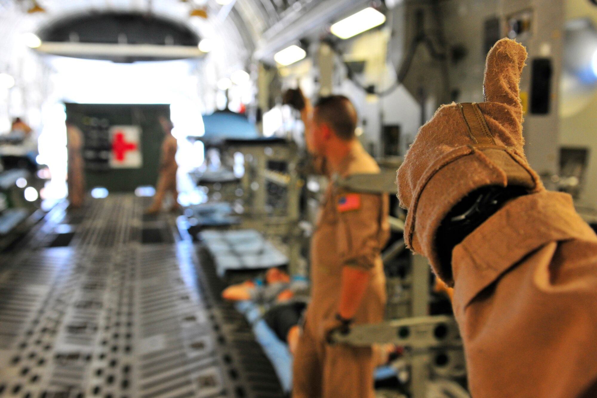 Master Sgt. Rick Bennett gives the signal to load more patients on a C-17 Globemaster III at Bagram Airfield, Afghanistan, July 2, 2010. More than 60 U.S. service members were evacuated to a regional hospital for care in Germany. Sergeant Bennett is a flight medic deployed from Ramstein Air Base, Germany. (U.S. Air Force photo/Staff Sgt. Christopher Boitz)