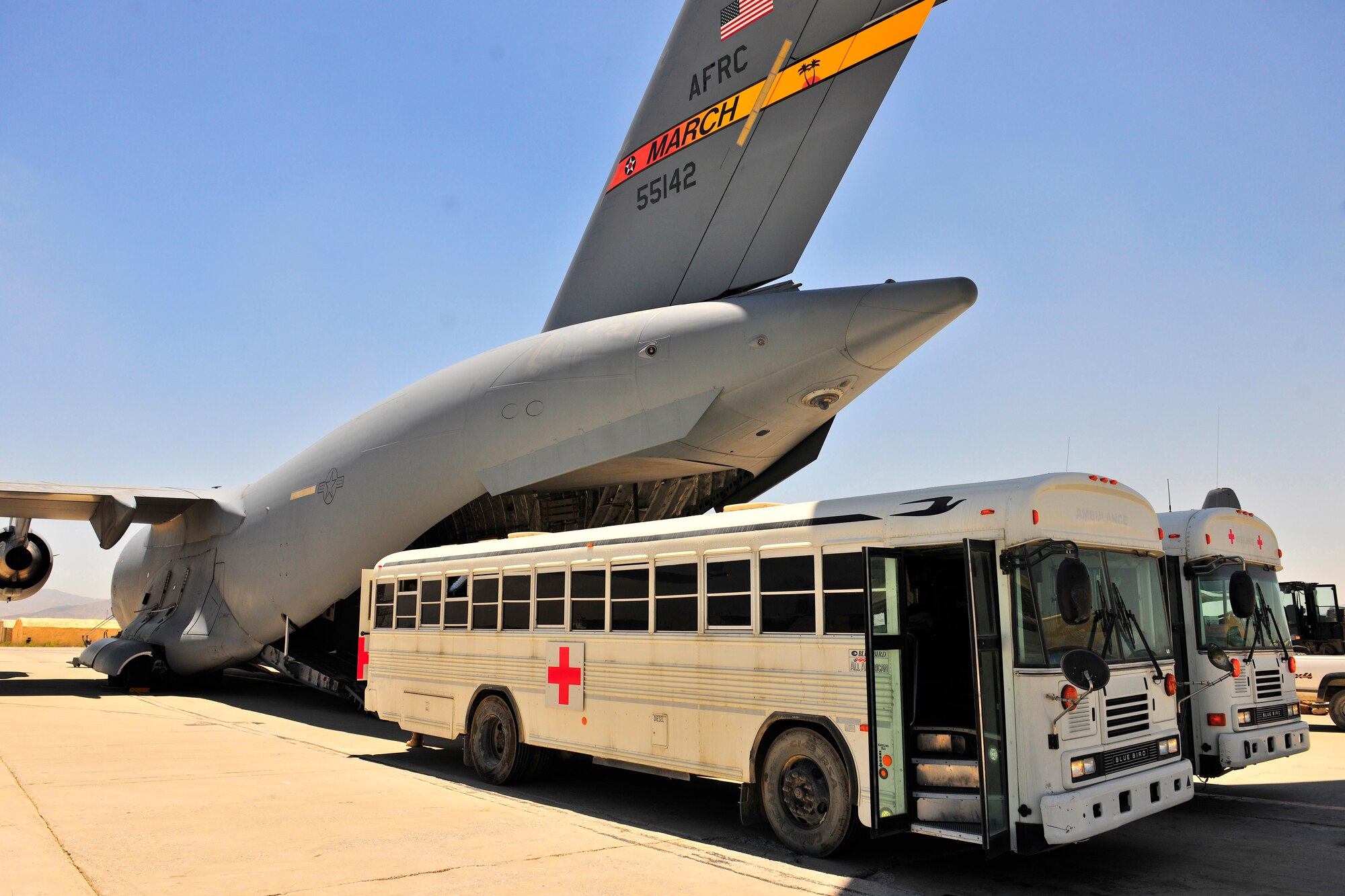 Two medical buses wait to load patients on a C-17 Globemaster III at Bagram Airfield, Afghanistan, July 2, 2010. More than 60 U.S. service members were evacuated to a regional hospital for care in Germany. (U.S. Air Force photo/Staff Sgt. Christopher Boitz)