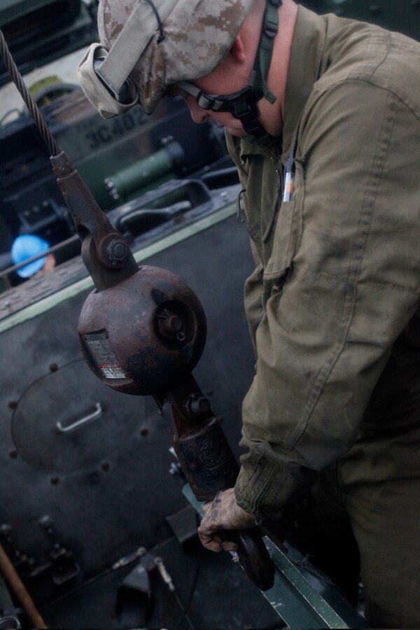 A U.S. Marine with 4th Platoon, Charlie Company, 3rd Assault Amphibian Battalion, 1st Marine Division spends July 4, 2010, repairing the transmission of an amphibious assault vehicle on a beach in Ancon, Peru. The Marines are embarked aboard USS New Orleans in support of Partnership of the Americas 2010 (POA-10) and Southern Exchange 2010 (SE-10), two separate U.S. Marine Corps Forces, South (MARFORSOUTH) exercises being executed concurrently in 2010 because of a location change due to the earthquake in Chile in late February.