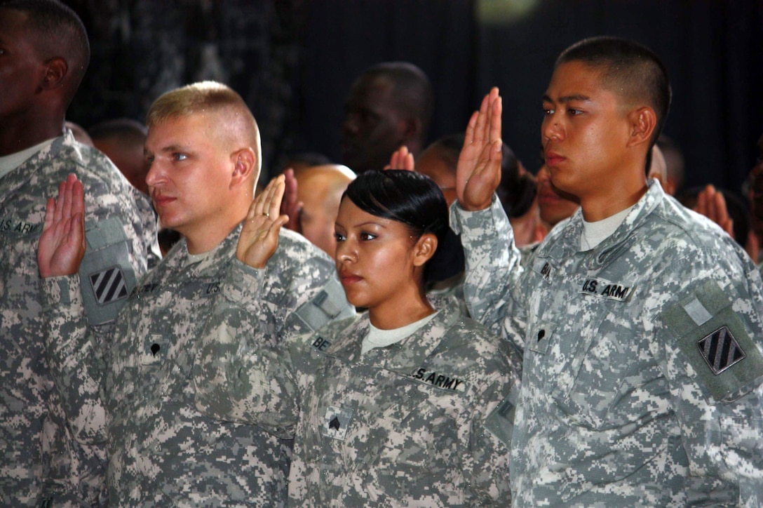 U.S. troops take the citizenship oath during a naturalization ceremony in Al Faw Palace on Camp Victory, Iraq, July 4, 2010. More than 150 servicemembers became citizens in a ceremony attended by Vice President Joe Biden and his wife, Jill Biden. 