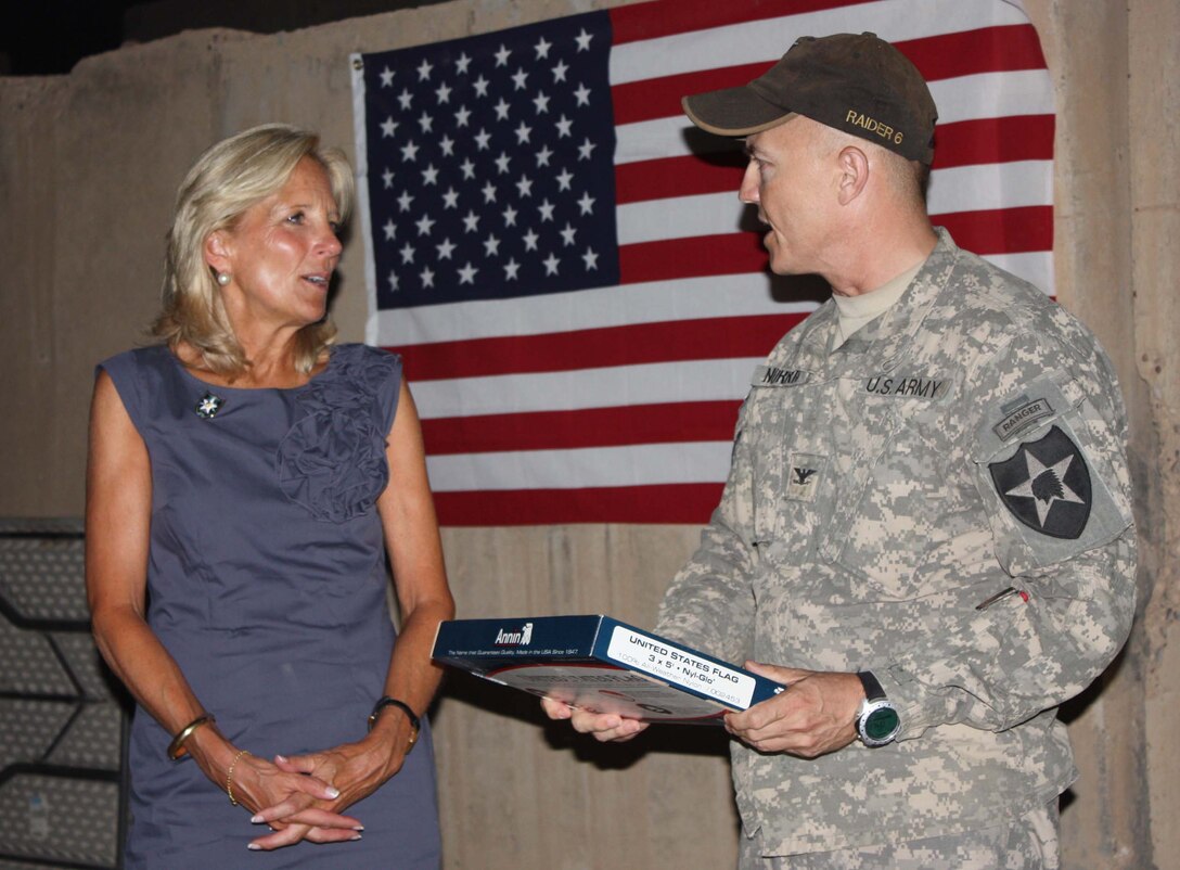 Army Col. John Norris, brigade commander, presents Dr. Jill Biden, wife of Vice President Joe Biden,  a U.S. flag that was flown over the 4th Stryker Brigade Combat Team's headquarters on Camp Victory, Iraq, July 4, 2010. 