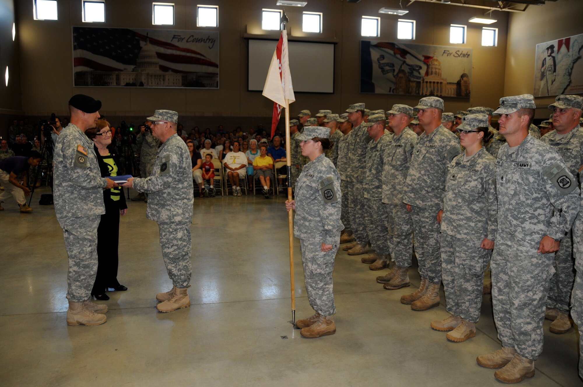 Iowa Lt. Gov. Patty Judge looks on as Iowa Adjutant General Brig. Gen. Timothy Orr presents an Iowa state flag to Col. Craig Bargfrede, 734th Agri-Business Development Team Commander, at the Team's Community Send-Off Ceremony on July 1 at Camp Dodge, Iowa. USAF Photo Capt. Peter Shinn, 734th ADT Public Affairs (Released)