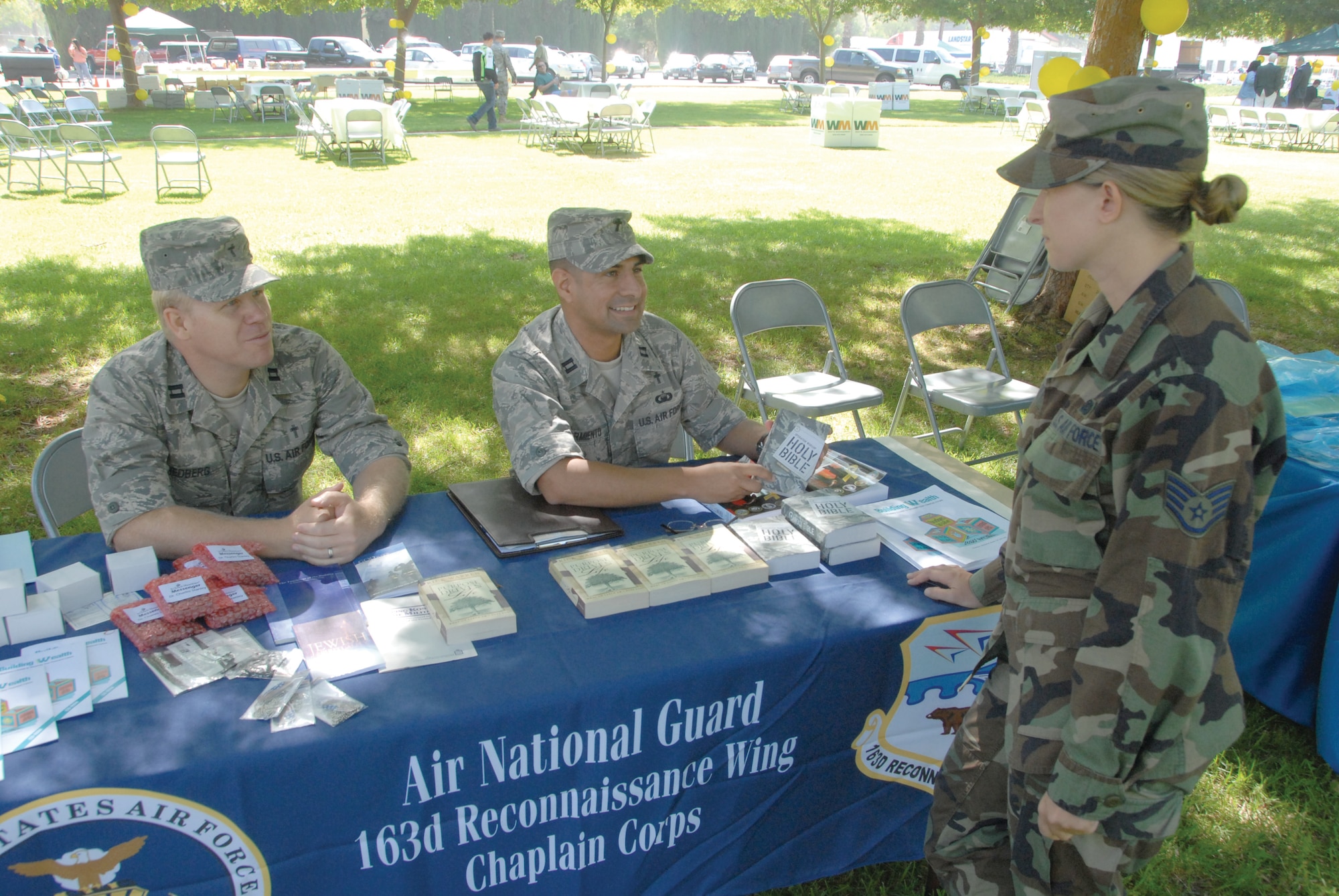 Captains Ethan Hedberg and David Sarmiento, 163rd Reconnaissance Wing Chaplain Corps, speak to Staff Sgt. Kelly Hobby who visited their chaplain’s booth at the Fun, Family and Fitness Day at LeMay Park, June 18. The 452nd Family Readiness Office hosted the event in support of Team March members who have been or will be deployed. (U.S. Air Force photo by Staff Sgt. Paul Duquette)