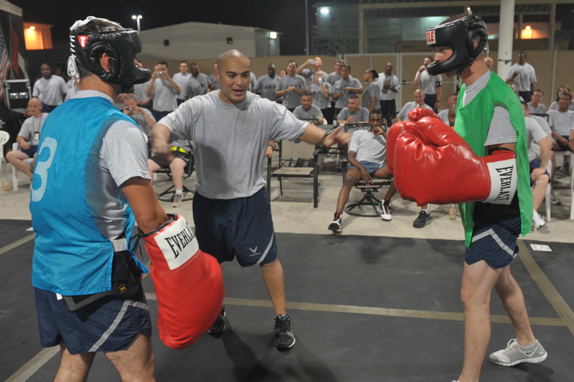 Referee Staff Sgt Raynard Ysukiyama separates brothers Staff Sgt. Brian Roub and Airman 1st Class Paul Roub during a fight night event July 4 at an undisclosed location in Southwest Asia. The event capped off a full day of events celebrating Independence Day here. (U.S. Air Force photo/Staff Sgt Jeremy Larlee)