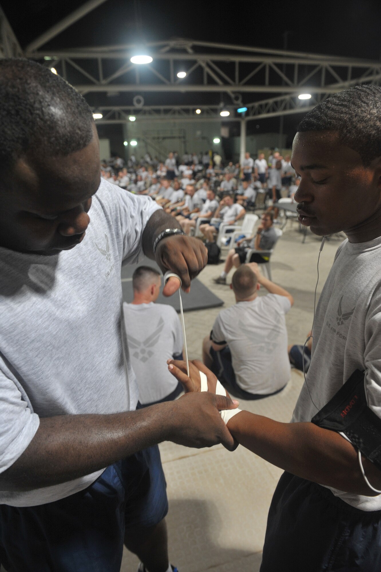 Senior Airman Glen Myers tapes the hands of Airman 1st Class Reggie “Mayhem” Moore in preparation for a fight night event July 4 at an undisclosed location in Southwest Asia. Airman Moore’s opponent Staff Sgt. George Wild threw in the towel after the first round. (U.S. Air Force photo/Staff Sgt Jeremy Larlee)