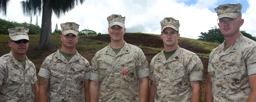 After receiving a Bronze Star with a “V” device for valor July 6 at U.S. Marine Corps Forces, Pacific Headquarters, Camp H. M. Smith, Hawaii, Sgt. Michael G. Dowling (center) credited his team for his award. Dowling, a scout sniper currently serving as the noncommissioned officer in charge for Regional Operations and Plans, MarForPac, was recognized for his actions while serving in Afghanistan as a scout sniper team leader.::r::::n::::r::::n::(Dowling’s team, from left to right) Lance Cpl. Will Betts, Cpl. Daniel Hilsdorf, Petty Officer 3rd Class Cory McGuire and Lance Cpl. Ken Cormier.