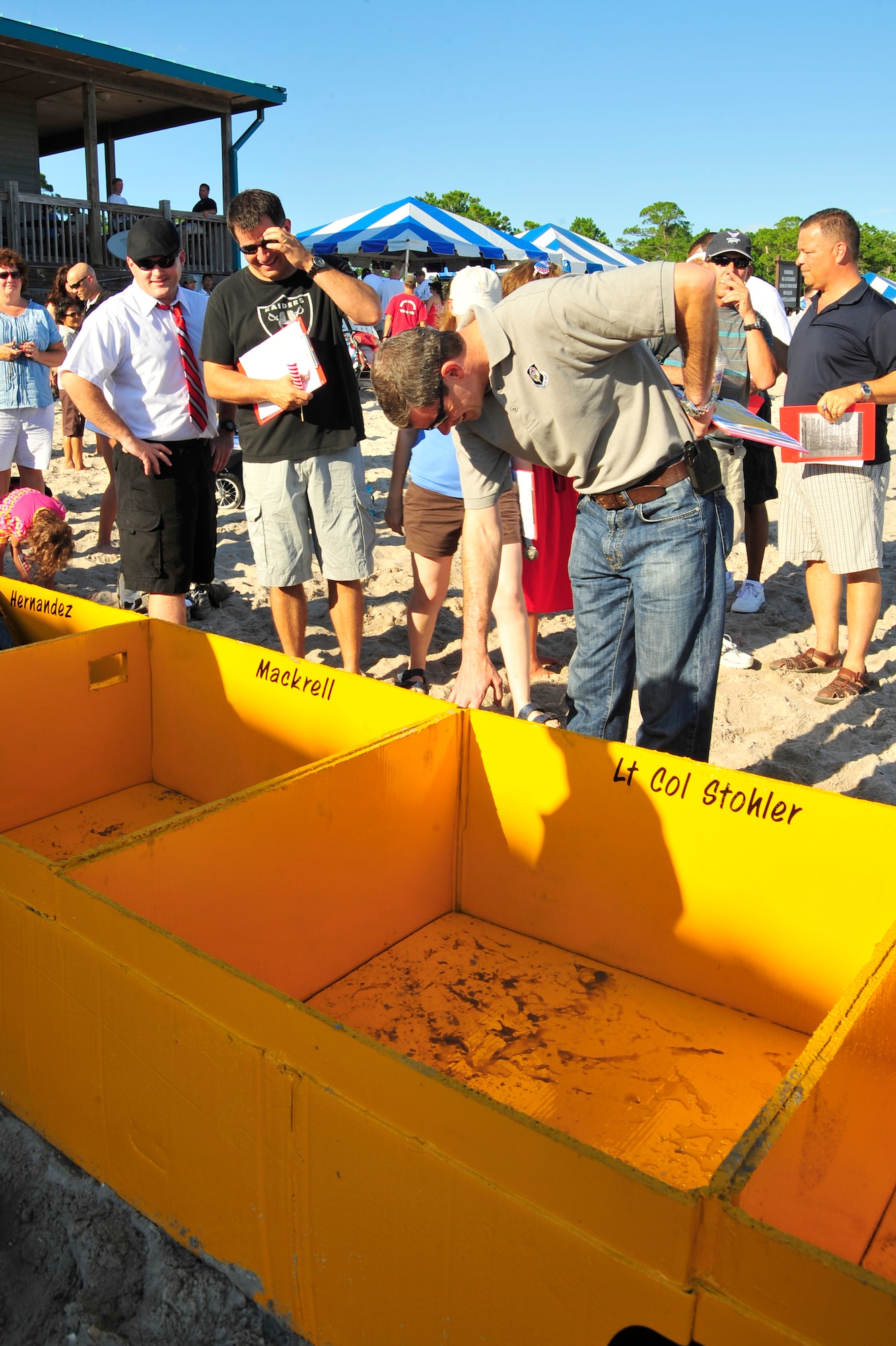 U.S. Air Force Col. Michael Plehn, 1st Special Operations Wing commander, and U.S. Air Force Col. Buck Elton, 1st Special Operations Group commander, inspect “The No. 2 Pencil” cardboard boat from the 1st Special Operations Equipment Maintenance Squadron during the 22nd Annual Cardboard Boat Regatta race at Hurlburt Field, Fla., July 2, 2010. The boats and paddles used in the race could only be constructed with plain cardboard, water based paint, water soluble glue, and rolls of duck, masking or packaging tapes. (DoD photo by Senior Airman Sheila deVera/RELEASED)