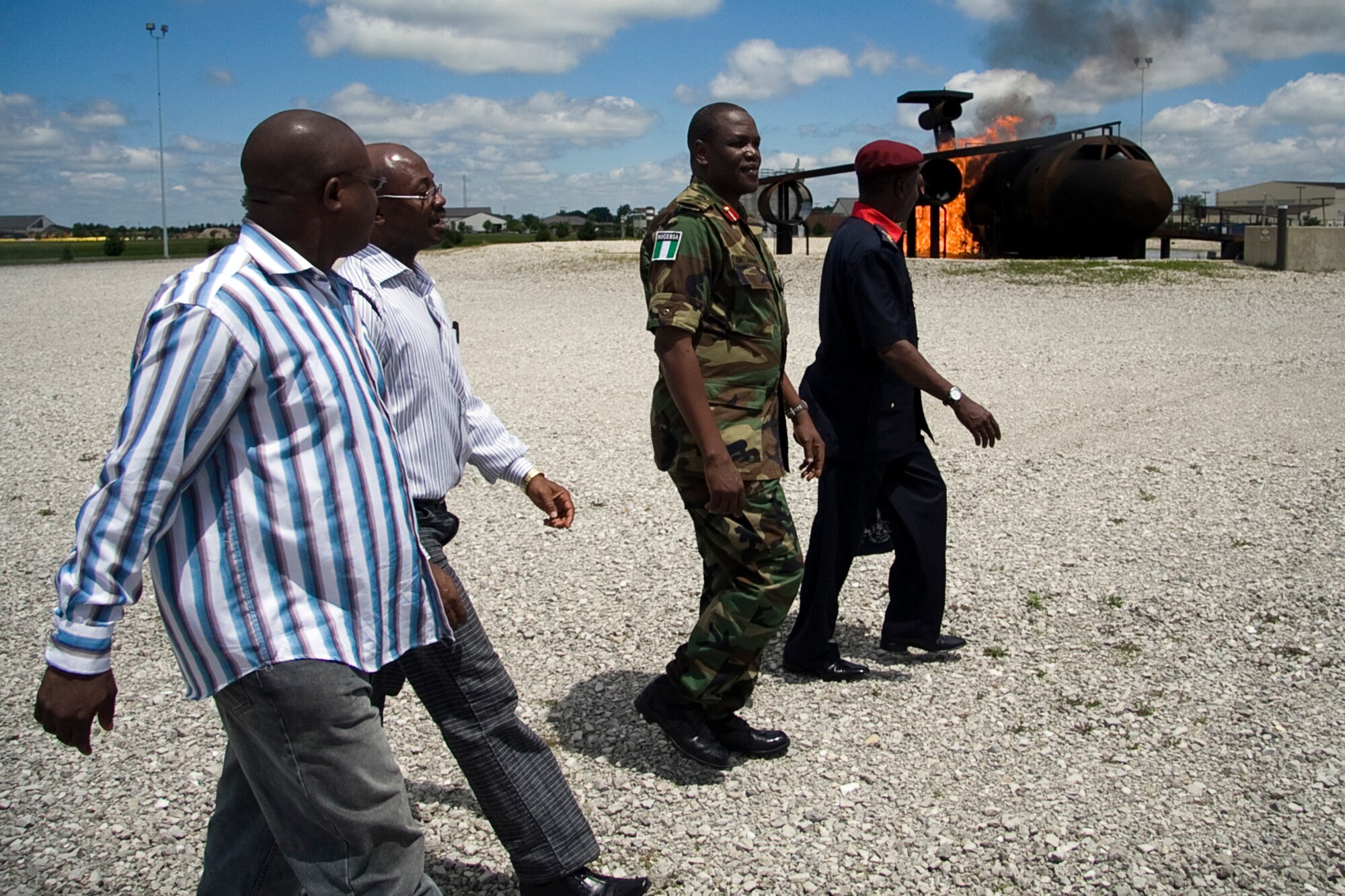 GRISSOM AIR RESERVE BASE, Ind. -- Four members of an emergency management delegation from Nigeria walk by an aircraft fire simulator as they prepare to witness a demonstration put on by the Grissom Fire Department here June 24. The Nigerians were in Indiana to witness an exercise held at the Indianapolis International Airport and to spend a day exchanging information with Grissom emergency managers and responders. Exchanges like these help foster cooperative relationship as well as provide valuable insight to all involved. (U.S. Air Force photo/Tech. Sgt. Mark R. W. Orders-Woempner)
