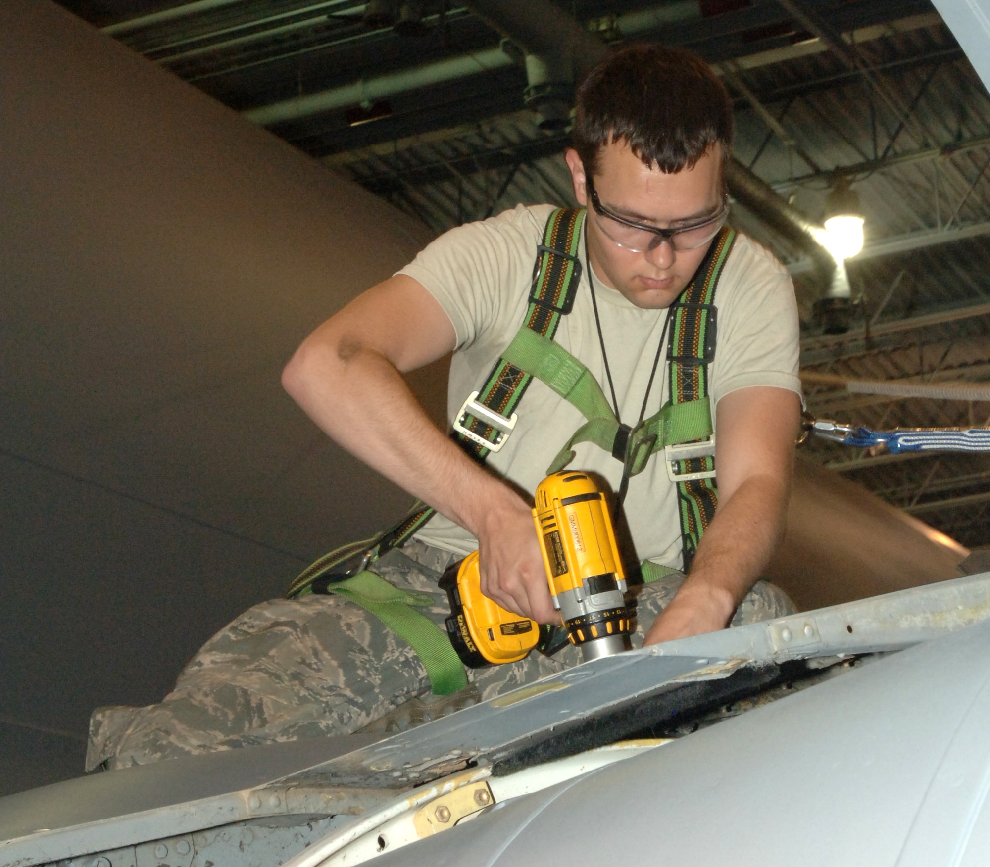 Airman 1st Class John Lesuer, 319th Aircraft Maintenance Squadron, removes screws from the trunnion panel on the right wing of a KC-135 Stratotanker so the top of the landing gear can be inspected during the periodic inspection July 6. The inspection is the last one the wing will perform on its tankers at Grand Forks Air Force Base as the wing continues its transition from KC-135 Stratotanker to unmanned aerial systems. (U.S. Air Force photo by Airman 1st Class Rachel Martinez)