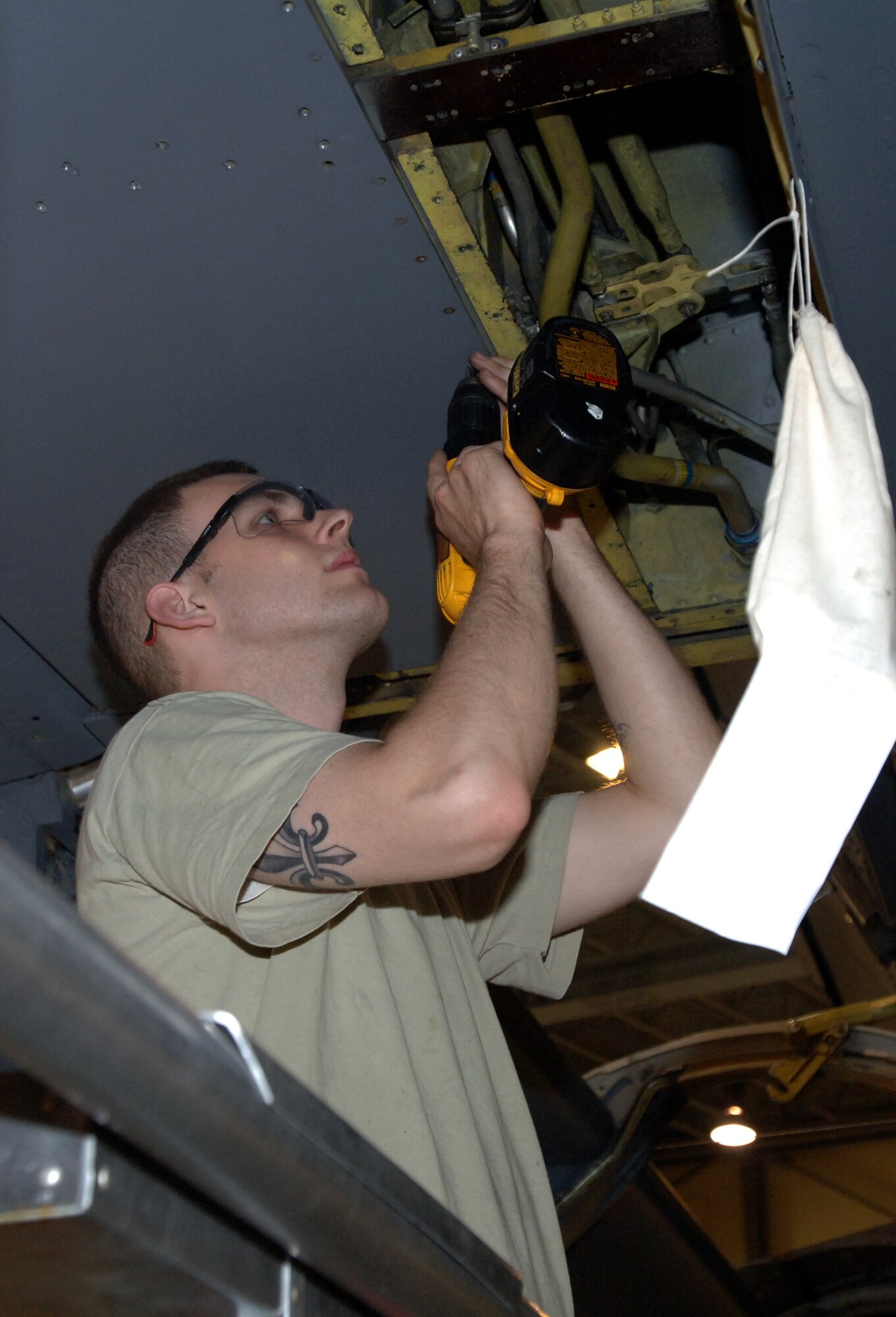 Airman 1st Class Jeremy Garrett, 319th Aircraft Maintenance Squadron, removes screws from the balance bay panel on the left wing of a KC-135 Stratotanker during the periodic inspection July 6. The inspection is the last one the wing will perform on its tankers at Grand Forks Air Force Base as the wing continues its transition from KC-135 Stratotanker to unmanned aerial systems. (U.S. Air Force photo by Airman 1st Class Rachel Martinez)