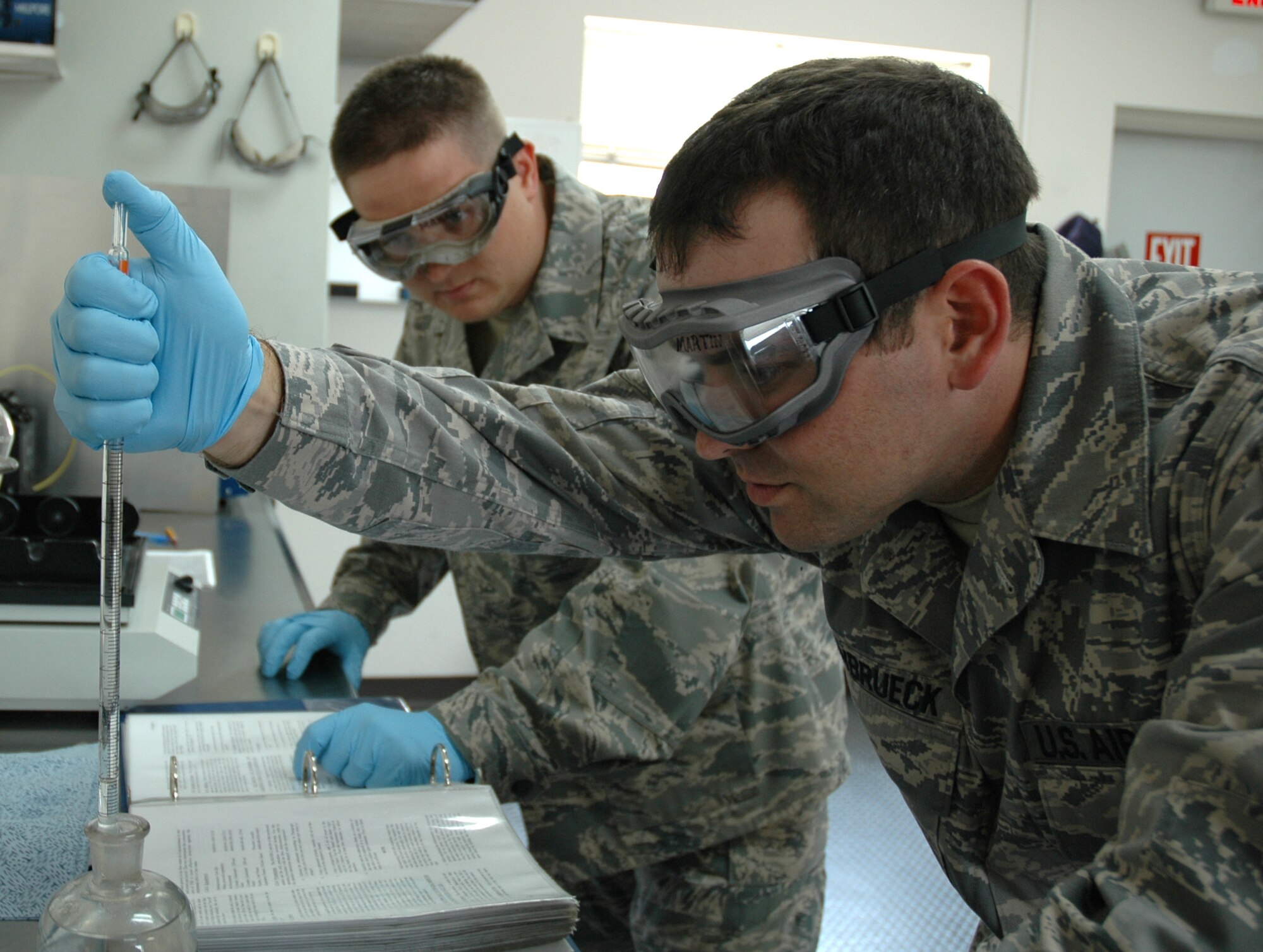 DOVER AIR FORCE BASE, Del.- Tech. Sgt. David Jackson (left), an air reserve technician with the 512th Logistics Readiness Flight here, trains his troop Staff Sgt. James Steinbrueck, 512th LRF Fuels training monitor, on the proper testing procedure for a fuel system icing inhibitor analysis, which lowers the freezing point of small quantities of free water in fuel. Sergeant Jackson was nominated as Air Force Reserve Command's representative for the 2010 Airlift Tanker Association Young Leadership Award for the NCO catagory in June. He will compete for the award at the Air Mobility Command level in October. (U.S. Air Force photo/Master Sgt. Jake Chappelle)