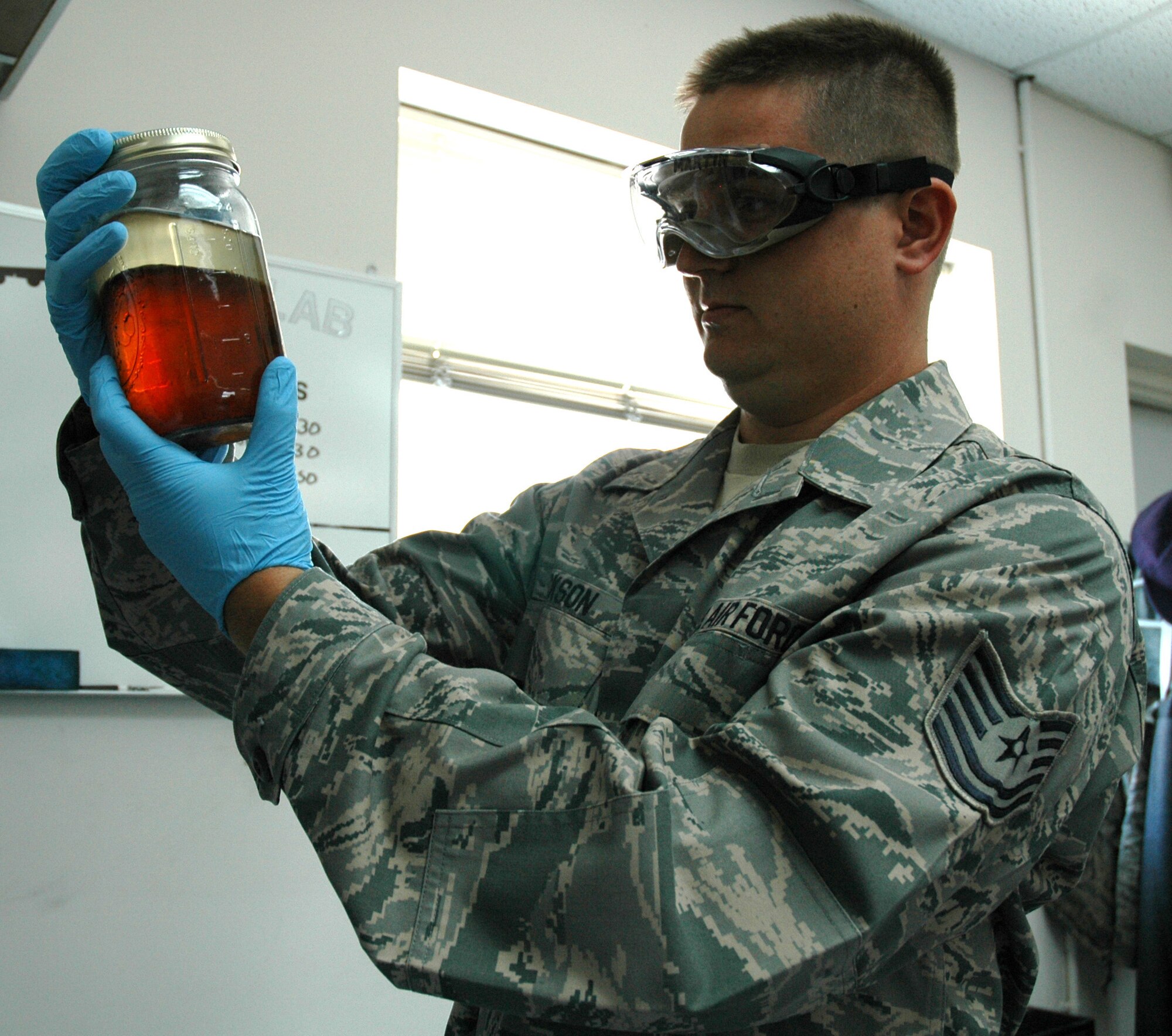 DOVER AIR FORCE BASE, Del.- Tech. Sgt. David Jackson, 512th Logistics Readiness Flight fuels shop NCO in-charge here, examines a demonstration fuel sample to show fuels specialists the various types of contamination that can occur in fuel systems. Sergeant Jackson, an air reserve technician, was nominated as Air Force Reserve Command's representative for the 2010 Airlift Tanker Association Young Leadership Award for the NCO catagory in June. He will compete for the award at the Air Mobility Command level in October. (U.S. Air Force photo/Master Sgt. Jake Chappelle)
