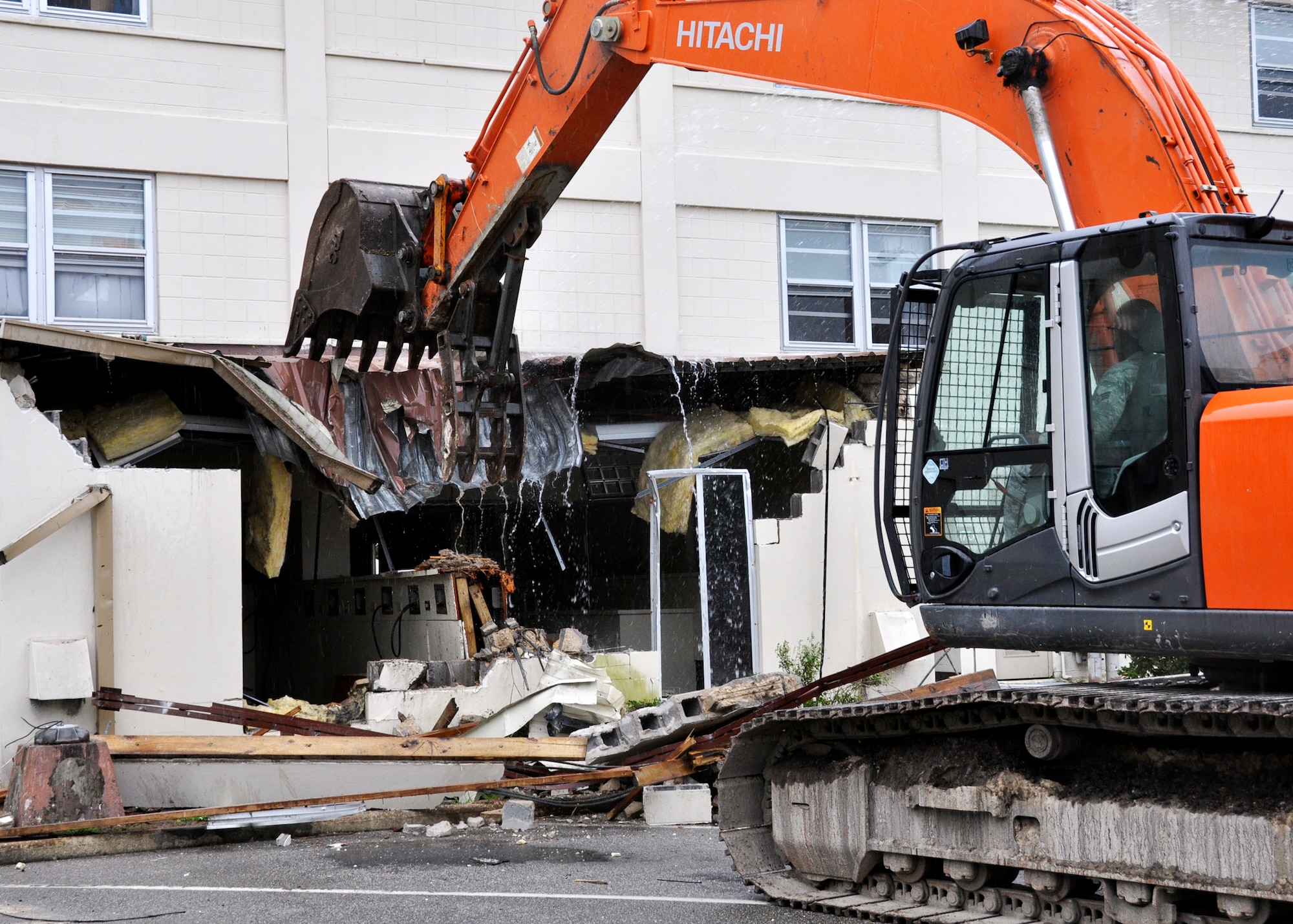 Senior Airman Isaac Stuckey, 96th Security Forces Squadron,  starts the demolition of Dorm 17, the last of the old dorms along Eglin Boulevard, July 6.  Airman Stuckey spent eight months in the “old” dorms before deploying.  He also lived in the new quad-style dorms as well and said they were “much better.”  According to 96th Civil Engineer Group, the dorm will be completely leveled and cleaned up in eight weeks.  All of the concrete within the structure will be recycled.  (U.S. Air Force photo/Samuel King Jr.)