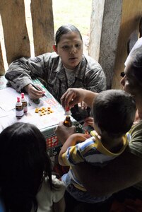 LOS PLANES, Honduras --  Staff Sgt. Dulce Caron, a 612th Operations Support Squadron interpreter, goes over the usuage of vitamins and supplements with a Honduran family here June 28. Sergeant Caron was part of a medical readiness training exercise in which the Joint Task Force Bravo Medical Element assisted the Honduran Ministry of Health and South Dakota State University students in assessing the nutritional needs of Honduran children in rural areas. (U.S. Air Force photo/Tech. Sgt. Benjamin Rojek)