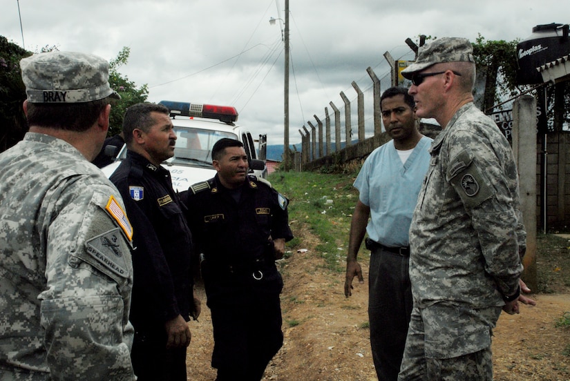LOS PLANES, Honduras --  Col. Gregory Reilly, right, speaks with doctors and police officers during a medical readiness training exercise here June 28. During the exercise, the Joint Task Force Bravo Medical Element assisted the Honduran Ministry of Health and South Dakota State University students in assessing the nutritional needs of children in rural areas. (U.S. Air Force photo/Tech. Sgt. Benjamin Rojek)