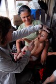 LOS PLANES, Honduras --  Dr. Teri Kemmer, left, an assistan professor of nutrition at South Dakota State Univeristy, conducts a check-up on a Honduran child during a medical readiness training exercise here June 28. Doctor Kemmer, who is a retired U.S. Army dietician officer, started the joint program in 2001 in order to both assist the Honduran Ministry of Health with the assessment of nutrition in rural areas and train military pediatricians. (U.S. Air Force photo/Tech. Sgt. Benjamin Rojek)