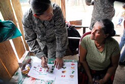 LOS PLANES, Honduras --  Staff Sgt. Dulce Caron, a 612th Operations Support Squadron interpreter, explains the benefits of a balanced diet with a Honduran woman during a medical readiness training exercise here June 28. This particular program, in which Sout Dakota State University students and Joint Task Force Bravo Medical Element doctors assist the Honduran Ministry of Health with assessing nutritional needs of children in rural areas, began in 2001. (U.S. Air Force photo/Tech. Sgt. Benjamin Rojek)