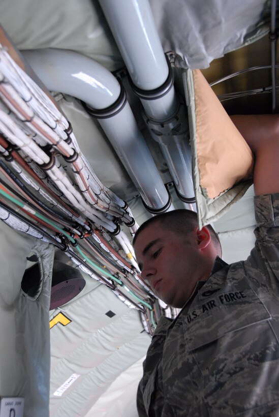 Senior Airman Jesse Reid adds power outlets to a KC-135R. The added outlets allow the tanker to airlift three times as many medical patients requiring electrically powered equipment. (photo by Staff Sgt. Jake Meyer)